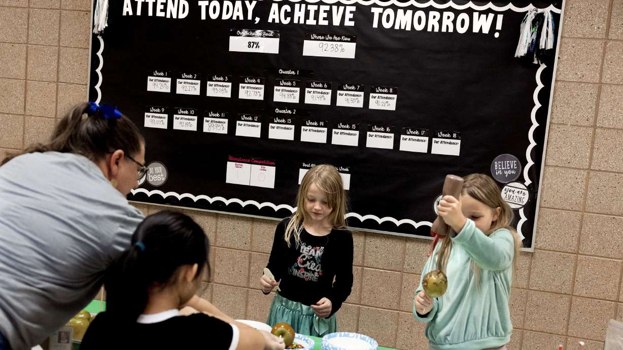 Heather Lane helps Masina Irons, Jazzmyn Brems and Leda Meek make candy apples that they earned for improving their attendance at Whittier Elementary School in West Valley City on Friday. A report shows nearly one-quarter of Utah students are chronically absent.
