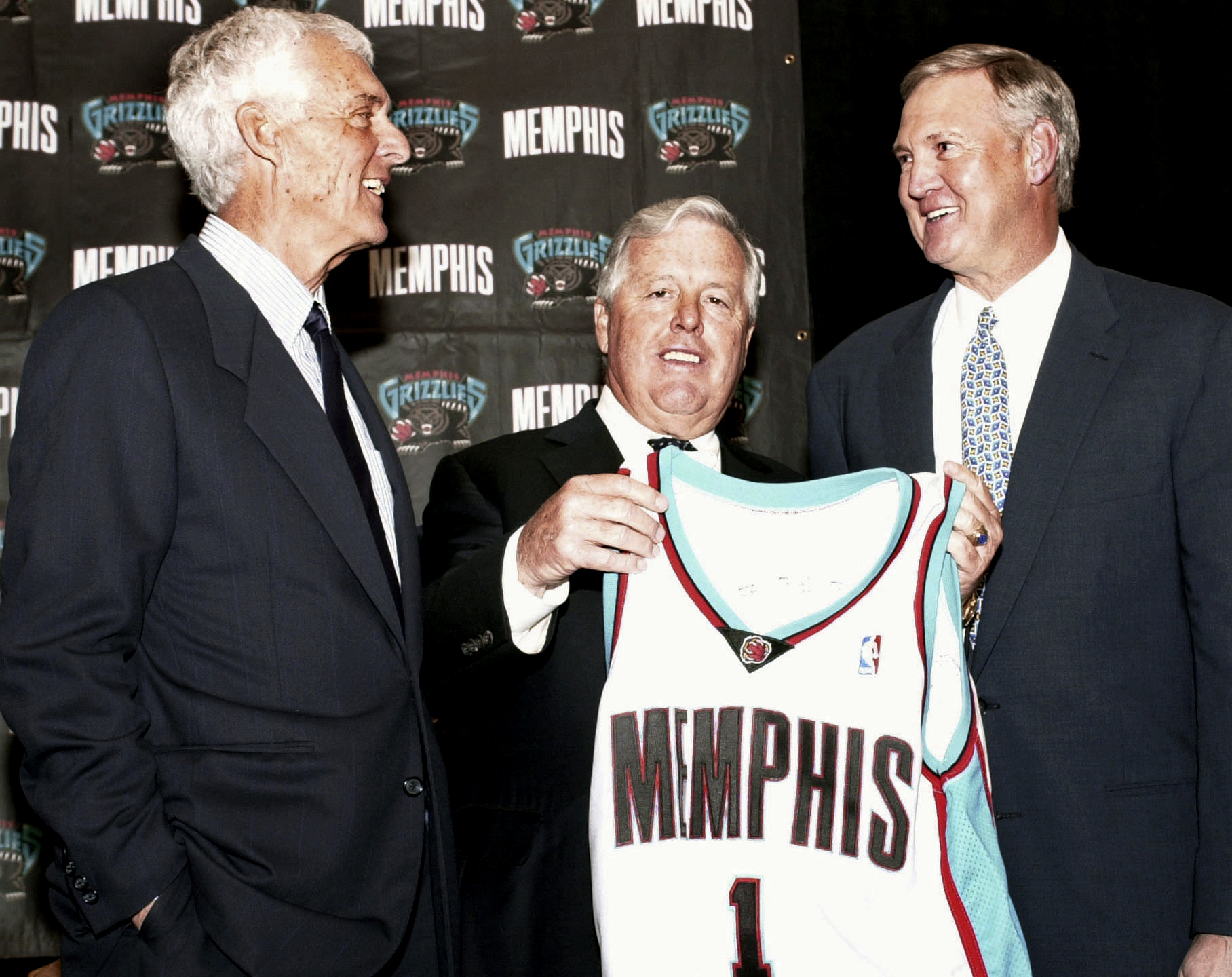 FILE - Michael Heisley, center, the Memphis Grizzlies majority owner, holds up a team jersey after announcing the hiring of Jerry West, right, as new president of basketball operations and Gary Colson, left, was introduced as West's assistant April 30, 2002, at an NBA news conference in Memphis, Tenn. Colson, who helped lobby to introduce the 3-point shot to men's college basketball during a 34-year coaching career that included stops at Fresno State, New Mexico and Pepperdine, died Friday, Nov. 3, 2023. He was 89. 