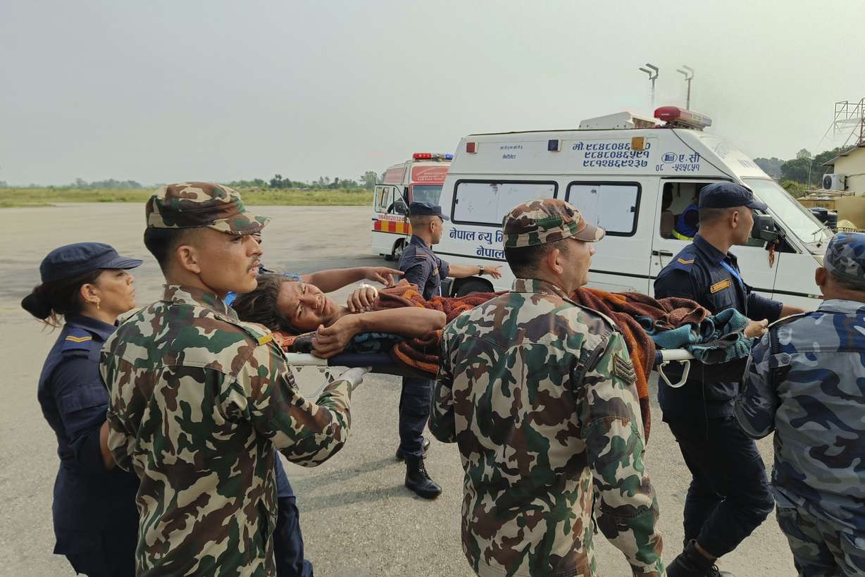 A woman airlifted from an earthquake-affected area is carried on a stretcher in Nepalgunj, Nepal, Saturday. A strong earthquake has shaken northwestern Nepal, and officials say more than 100 people are dead and dozens more injured as rescuers search mountain villages.