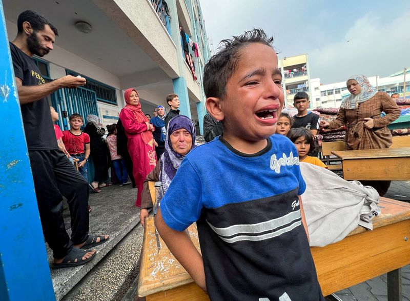 A Palestinian boy reacts at the damages at a UN-run school sheltering displaced people, following an Israeli strike, in Jabalia in the northern Gaza Strip on Thursday.