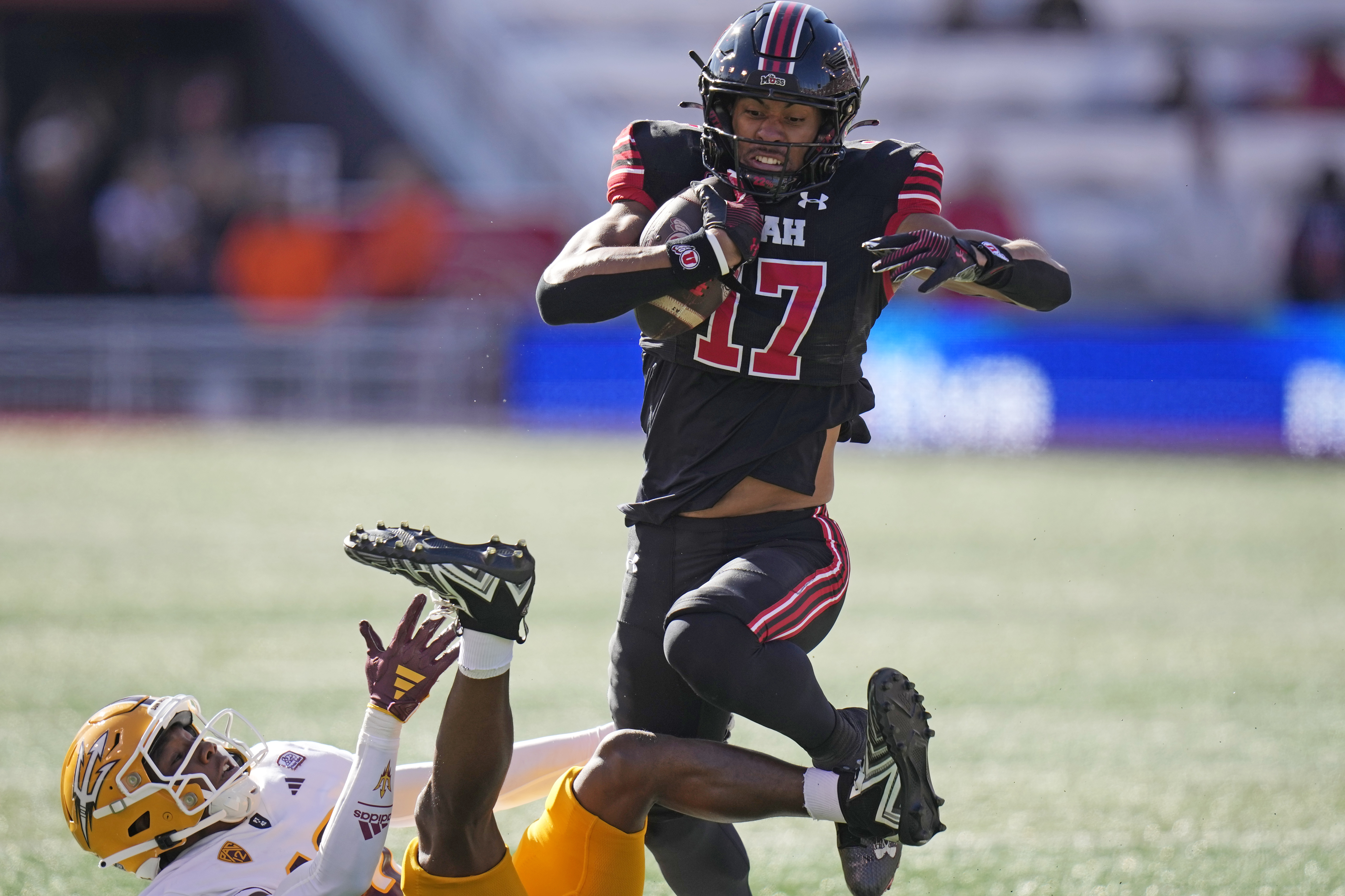 Utah wide receiver Devaughn Vele (17) leaps over Arizona State defensive back Ed Woods (10) during the first half of an NCAA college football game Saturday, Nov. 4, 2023, in Salt Lake City.