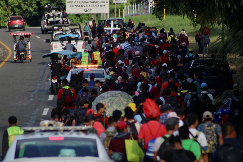 Migrants walk along the road in a caravan in an attempt to reach the U.S. border, in Tapachula, Mexico, Sunday.