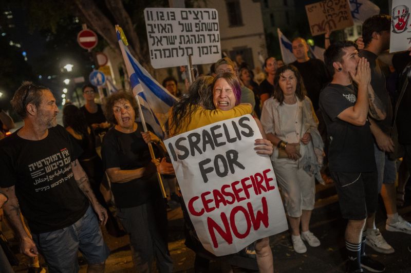 An Israeli woman calling for a cease-fire in the Gaza Strip is comforted by another protester after an argument with a right-wing Israeli in Tel Aviv, Israel, Saturday.