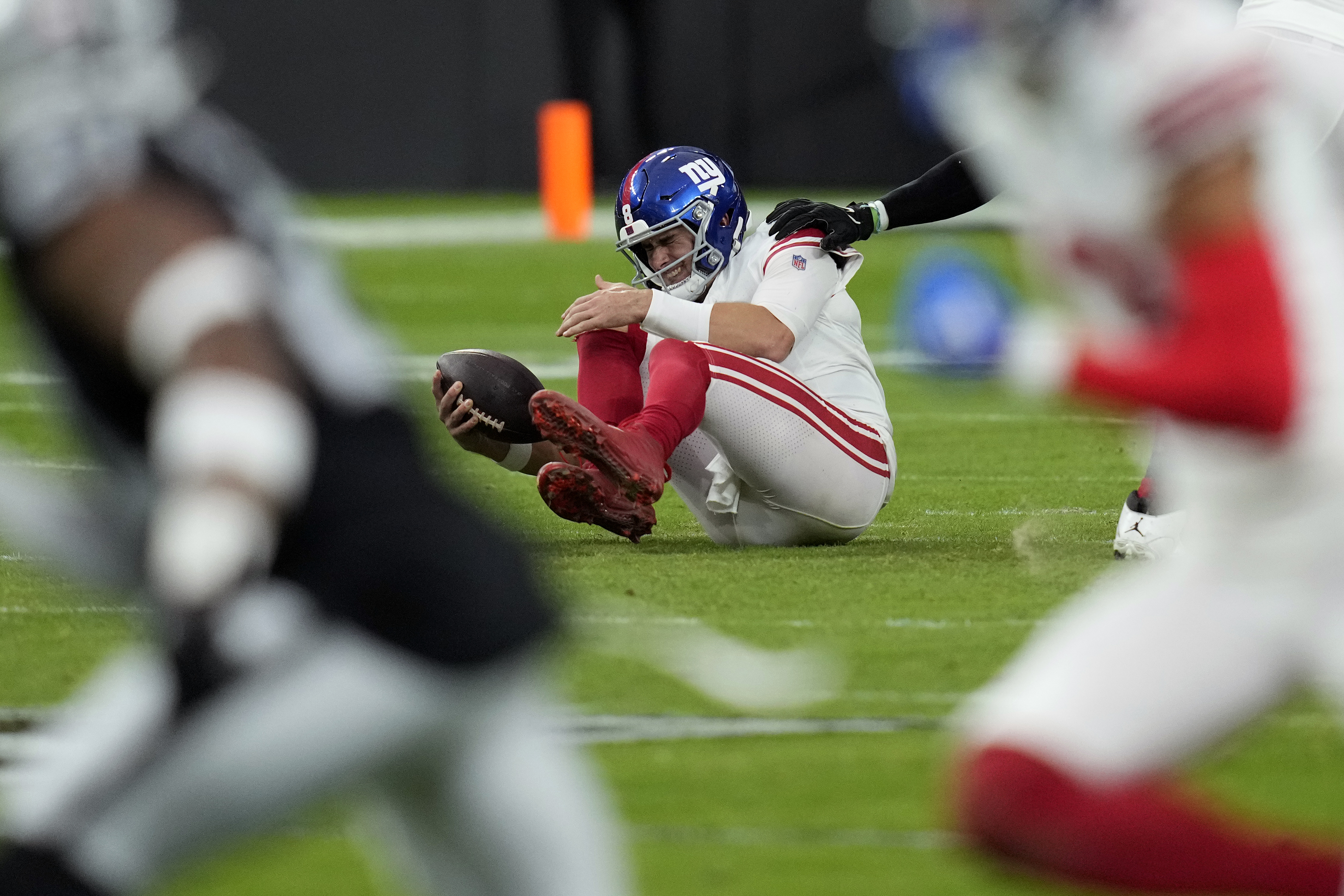 New York Giants quarterback Daniel Jones grimaces after a sack during the first half of an NFL football game against the Las Vegas Raiders, Sunday, Nov. 5, 2023, in Las Vegas. 