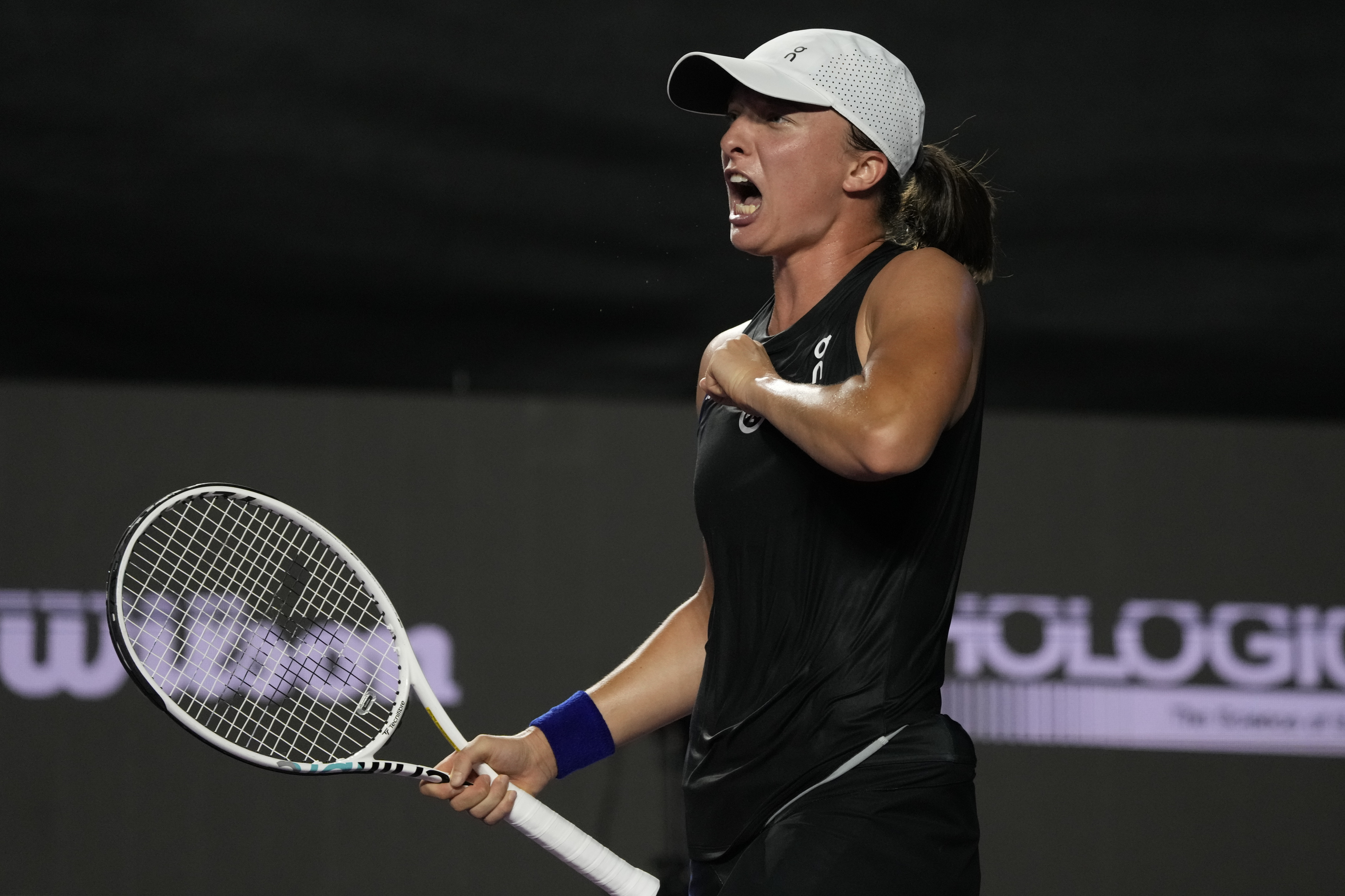 Iga Swiatek, of Poland, celebrates after defeating Aryna Sabalenka, of Belarus, during a women's singles semifinal match at the WTA Finals tennis championships, in Cancun , Mexico, Sunday, Nov. 5, 2023.