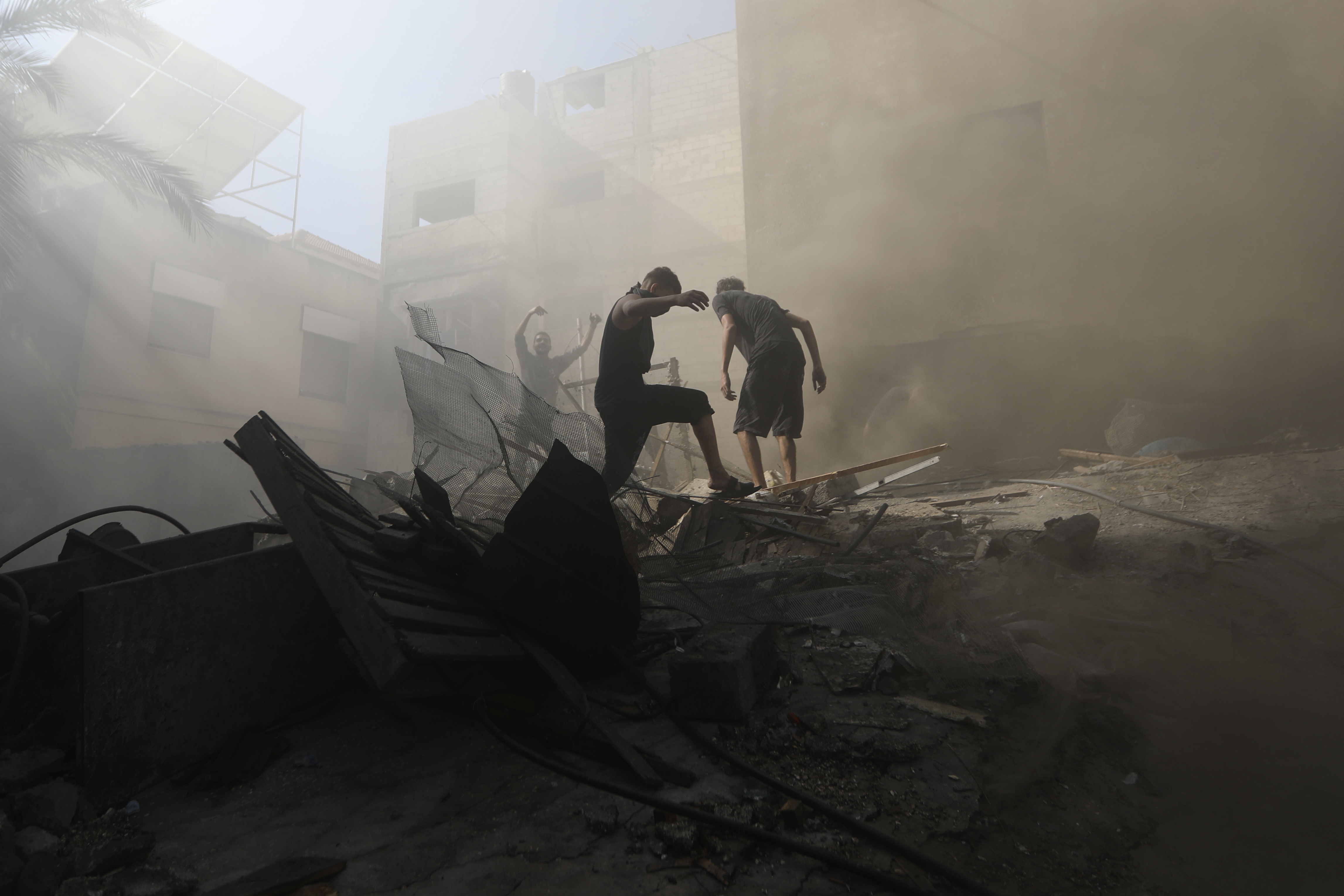 Palestinians look for survivors under the rubble of a destroyed building following an Israeli airstrike in Khan Younis refugee camp, southern Gaza Strip, Monday.