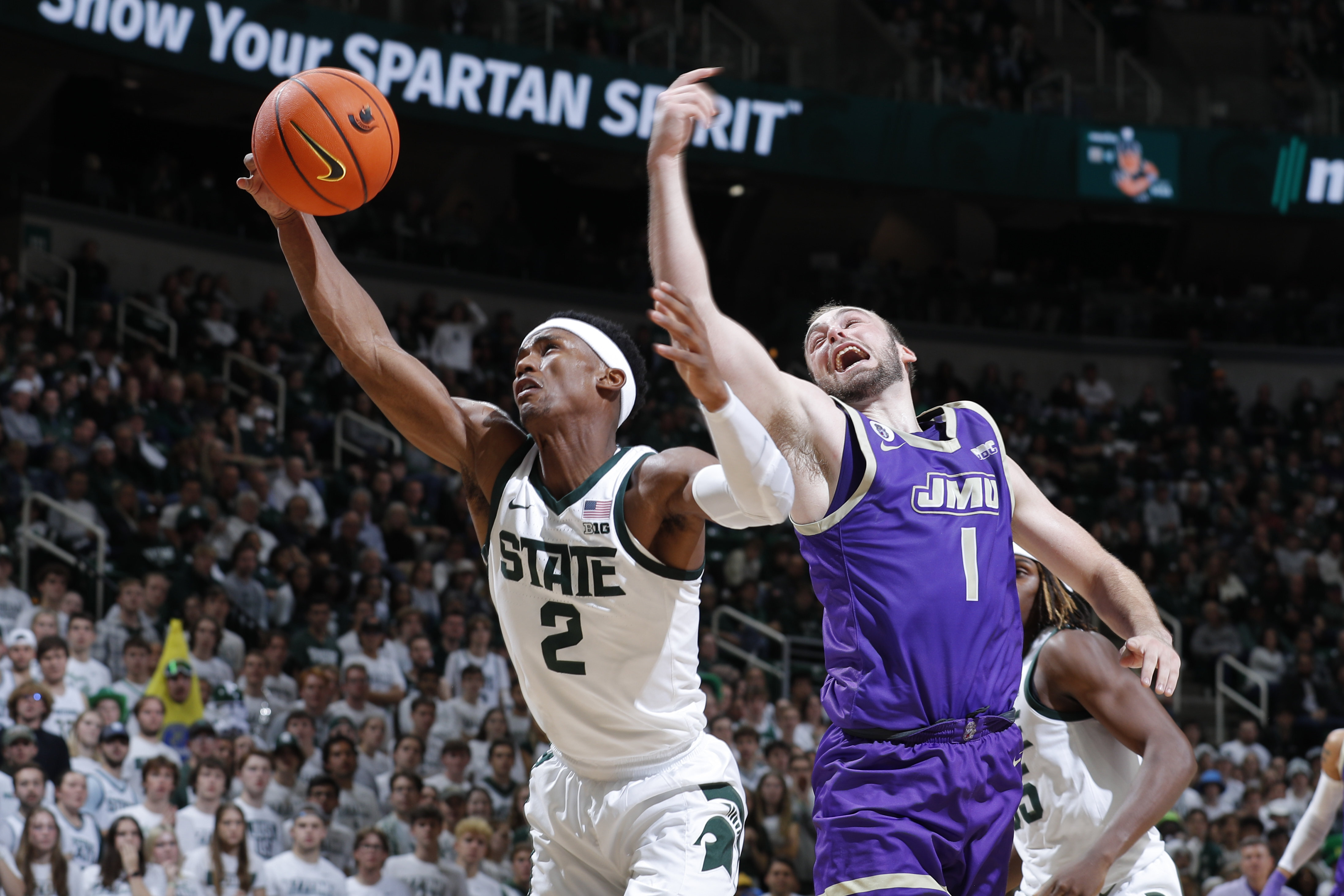 Michigan State's Tyson Walker, left, and James Madison's Noah Freidel vie for a rebound during the first half of an NCAA college basketball game, Monday, Nov. 6, 2023, in East Lansing, Mich. 