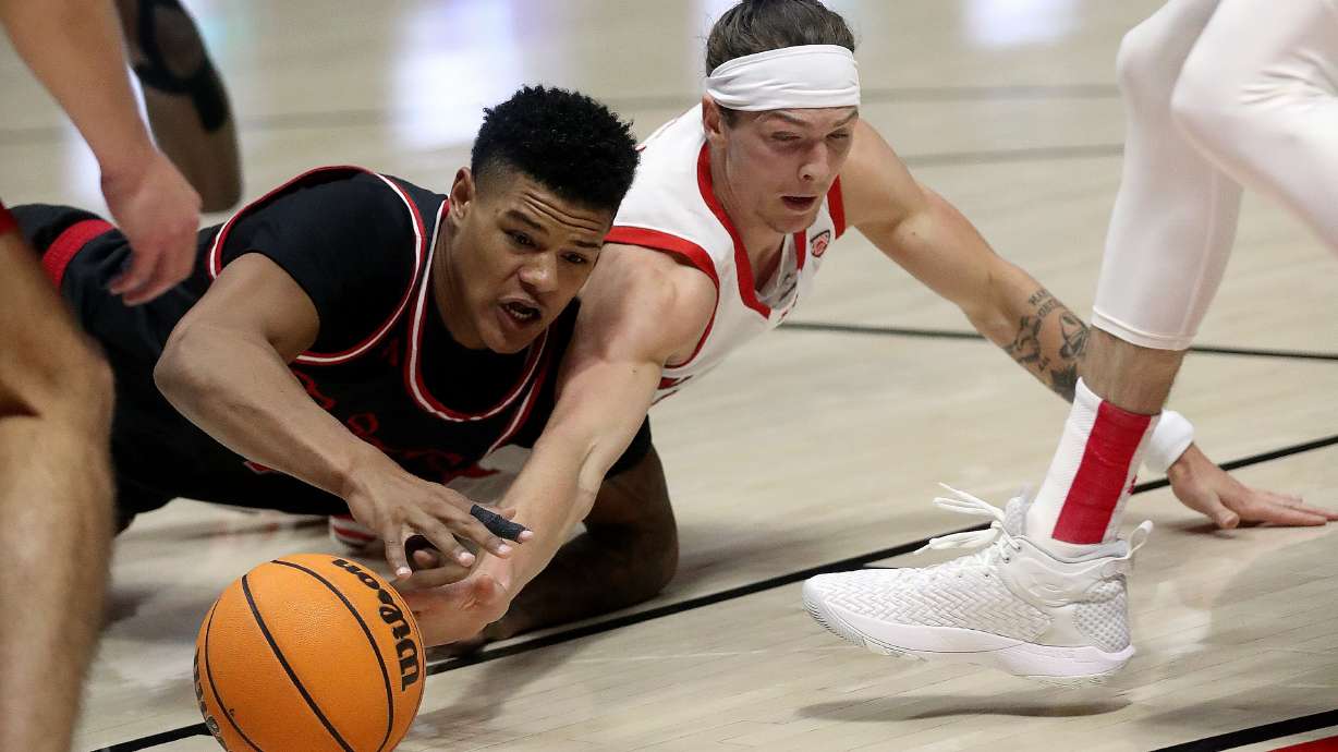 Eastern Washington Eagles forward LeJuan Watts (4) and Utah Utes guard Gabe Madsen (55) dive for the ball during a men’s basketball game at the Huntsman Center in Salt Lake City on Monday, Nov. 6, 2023.