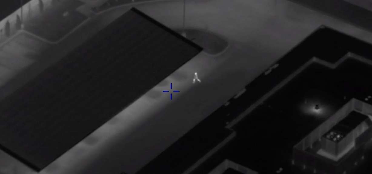 A man in the center is seen running across a parking lot after ditching a car while being chased by police on Feb. 17, 2022. A camera from a Utah Department of Public Safety helicopter is keeping track of his actions and relaying helpful information to officers on the ground.