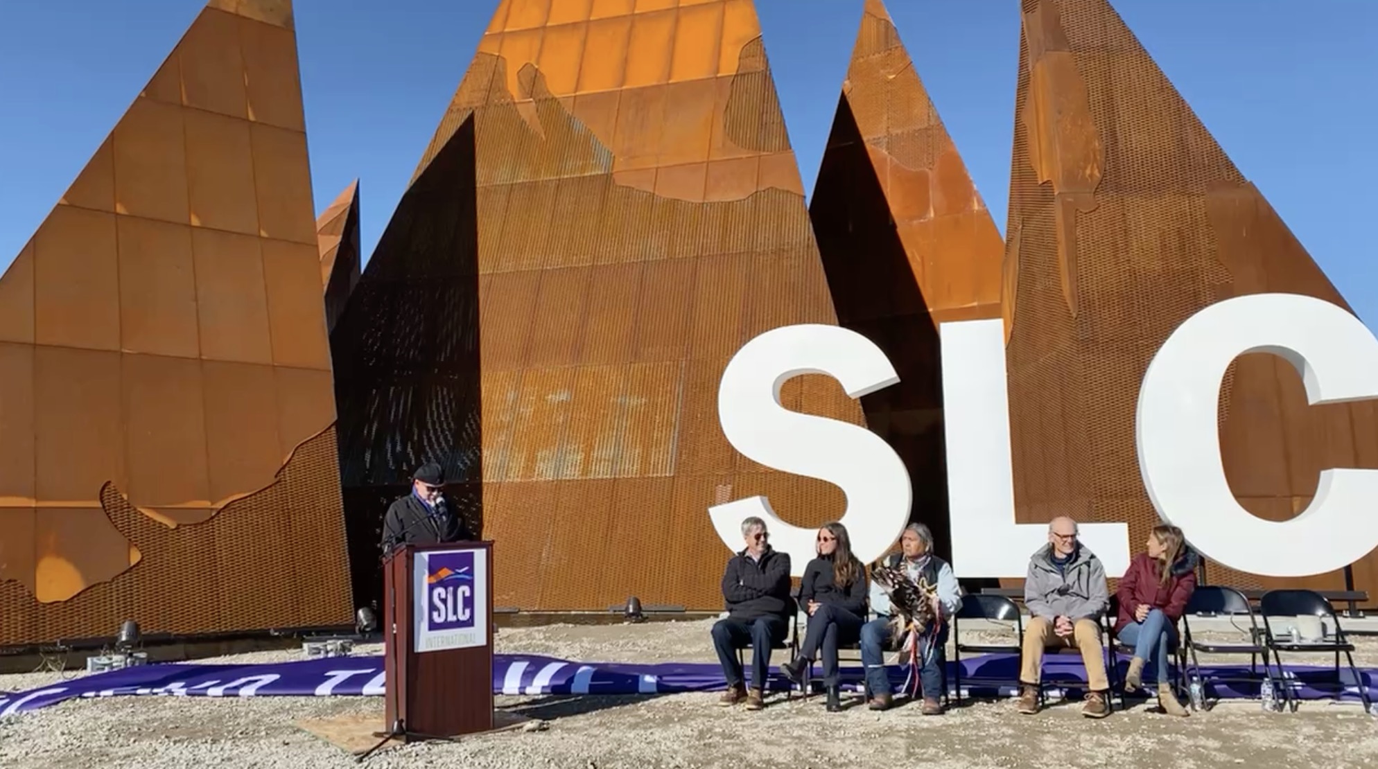 Artist Gordon Huether speaks during a ceremony Wednesday to unveil his latest sculpture, "The Peaks," outside of Salt Lake City International Airport.