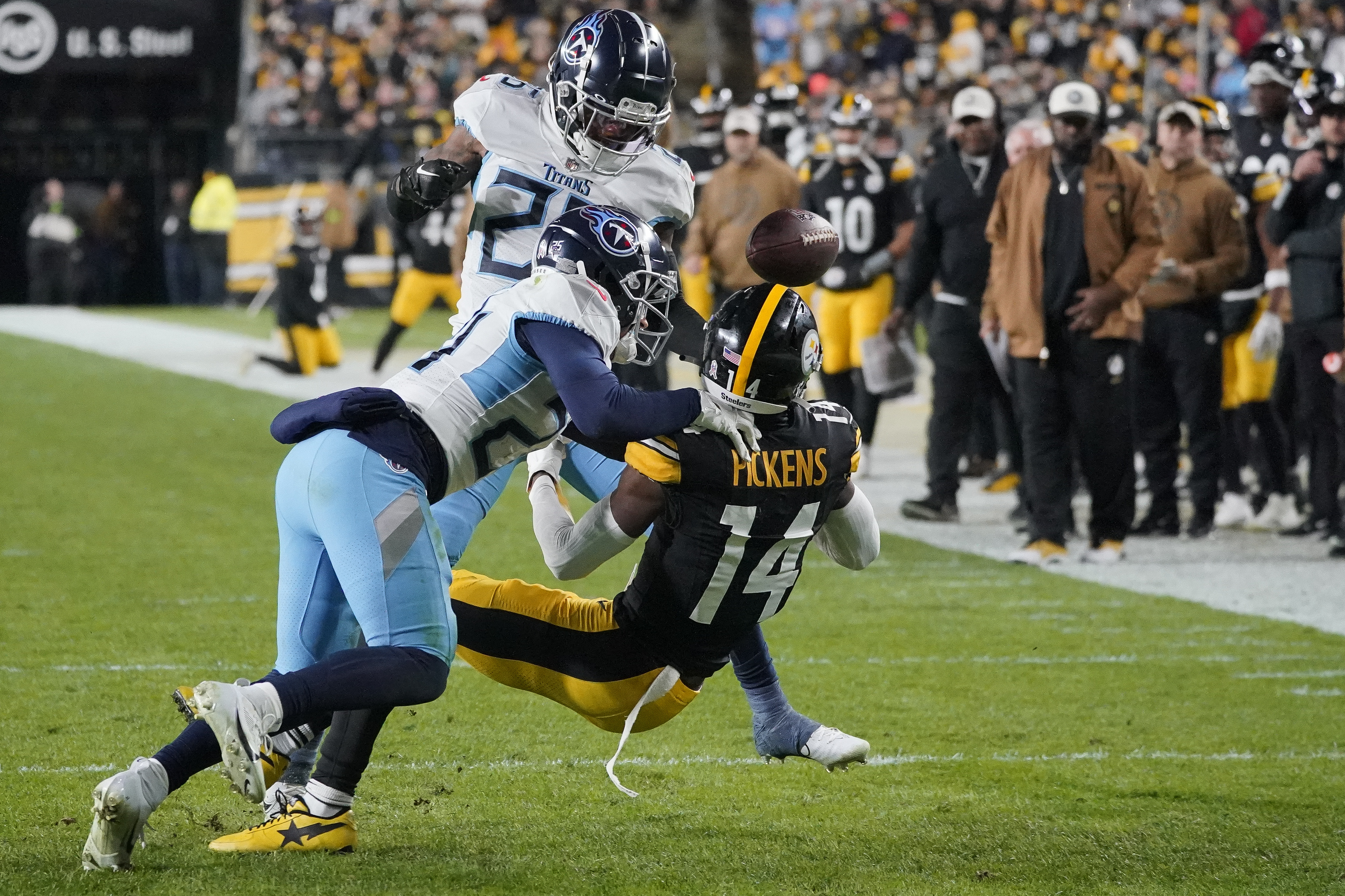 Pittsburgh Steelers wide receiver George Pickens (14) fumbles the ball out of bounds as he is tackled by Tennessee Titans defensive back Elijah Molden, left, and cornerback Kristian Fulton, behind, during the first half of an NFL football game Thursday, Nov. 2, 2023, in Pittsburgh. 