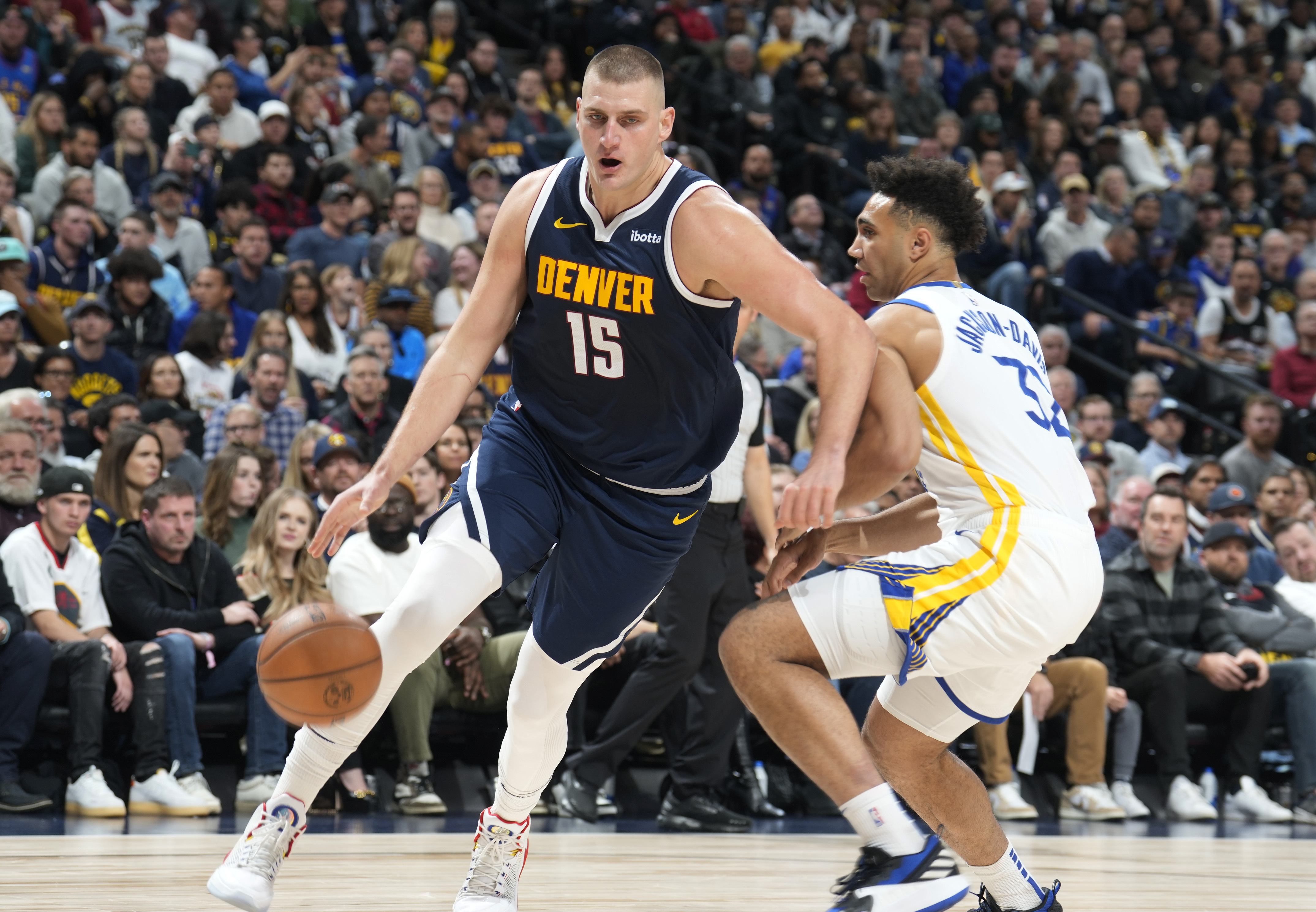 Denver Nuggets center Nikola Jokic, left, drives past Golden State Warriors forward Trayce Jackson-Davis in the first half of an NBA basketball game Wednesday, Nov. 8, 2023, in Denver. 