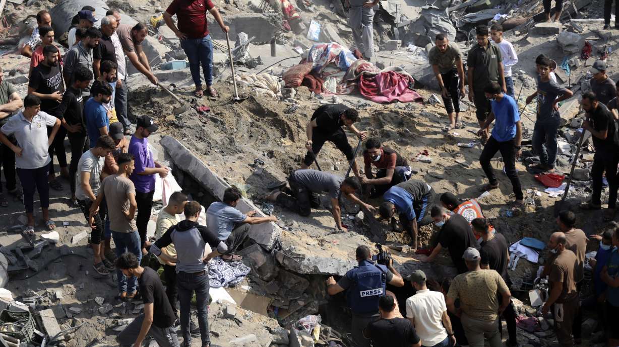Palestinians work among debris of buildings that were targeted by Israeli airstrikes in Jabaliya refugee camp, northern Gaza Strip, Wednesday. Israel has agreed to put in place four-hour daily humanitarian pauses in its assault on Hamas in northern Gaza, the White House said Thursday.