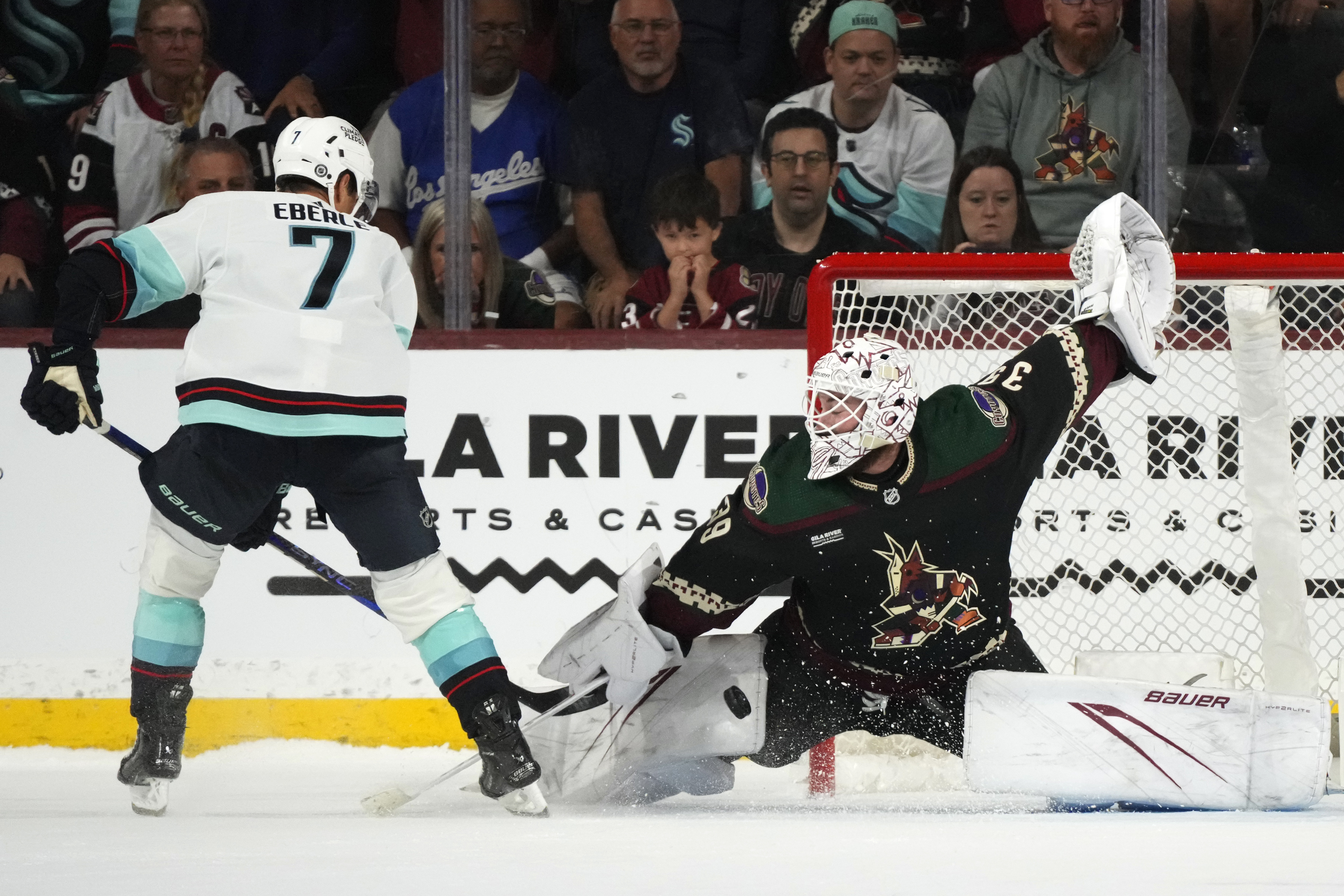 Arizona Coyotes goaltender Connor Ingram, right, makes a save on a shot by Seattle Kraken right wing Jordan Eberle (7) in a shootout during an NHL hockey game Tuesday, Nov. 7, 2023, in Tempe, Ariz. The Coyotes won 4-3.