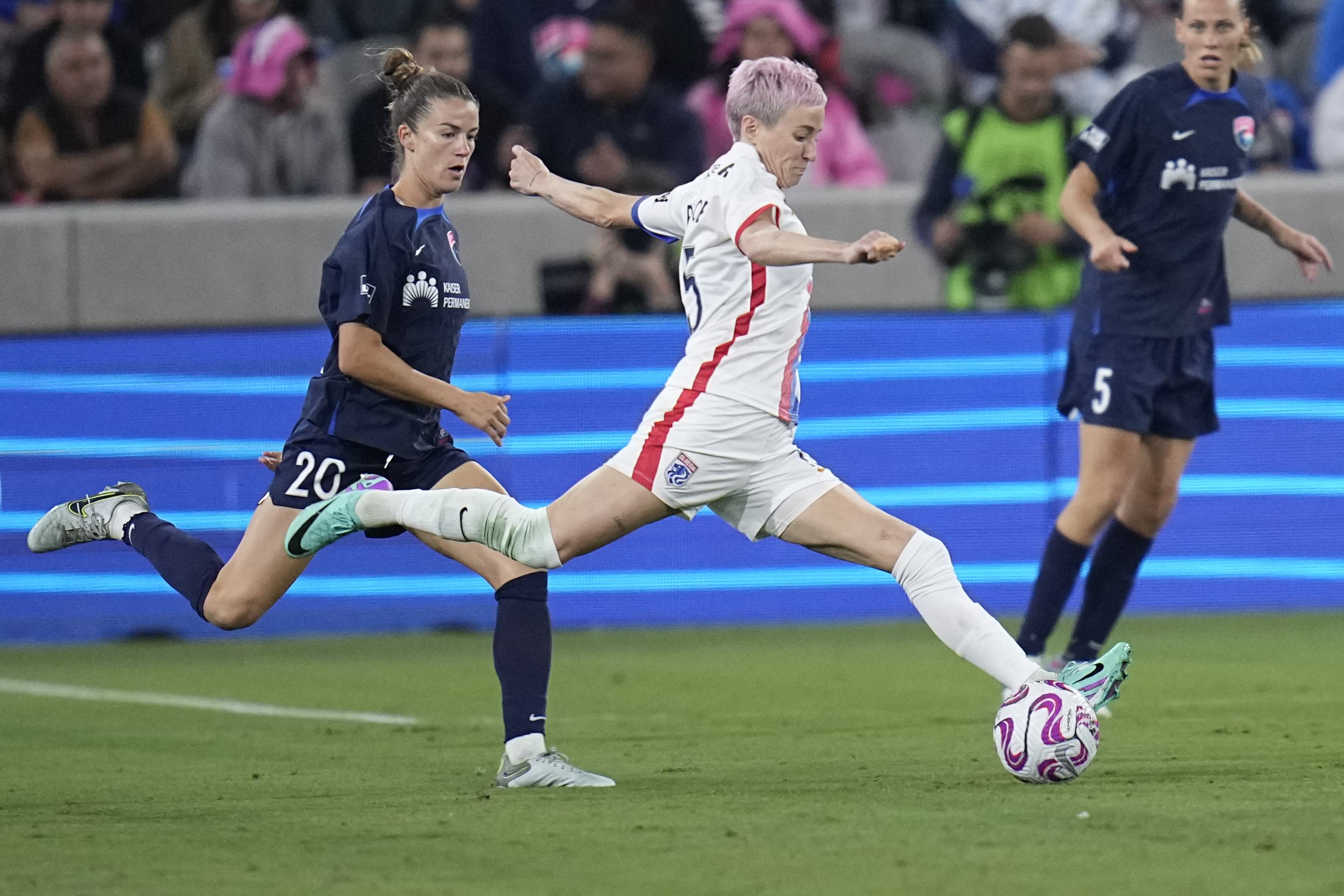 OL Reign forward Megan Rapinoe, center, passes the ball as San Diego Wave defender Christen Westphal defends during the second half of an NWSL semifinal playoff soccer match Sunday, Nov. 5, 2023, in San Diego. 