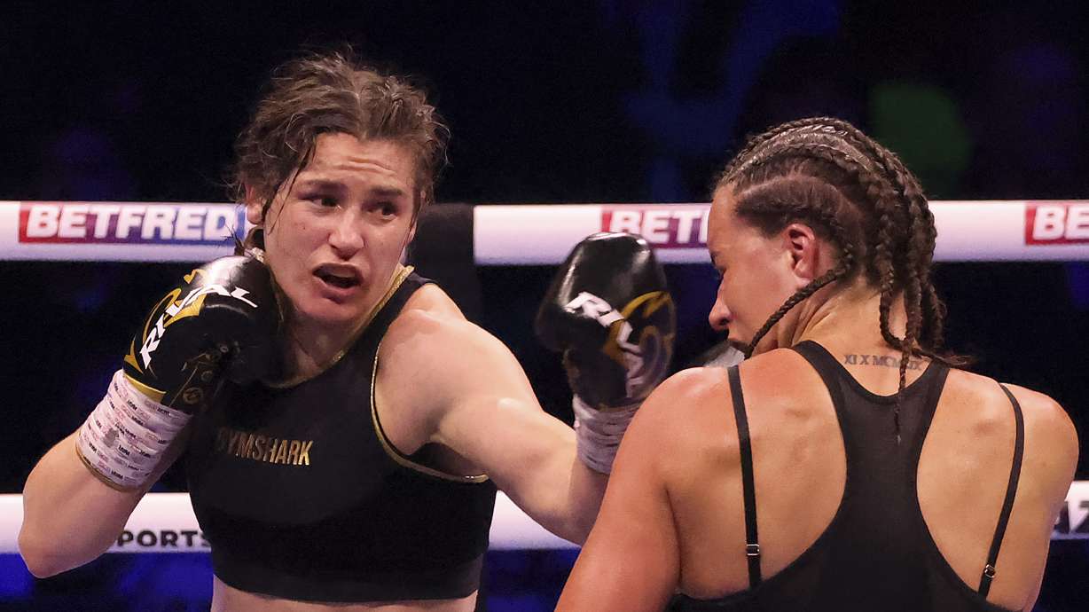 FILE - Ireland's Katie Taylor, left, lands a punch on Britain's Chantelle Cameron during their light-welterweight boxing world title fight at the 3Arena in Dublin, Ireland, Saturday, May 20, 2023. Undisputed lightweight champion Katie Taylor questioned whether women's boxing has the “strength and depth” to move to 3-minute rounds. The Irish fighter will try to avenge the only loss of her professional career when she faces Chantelle Cameron this month in a rematch of their fight in May.