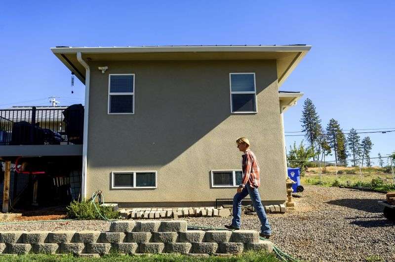 Heidi Lange walks behind her Paradise, Calif., home, Oct. 26. Lange, who rebuilt following the Camp Fire, is facing a homeowners insurance quote that jumped from $1,191 to $9,754.