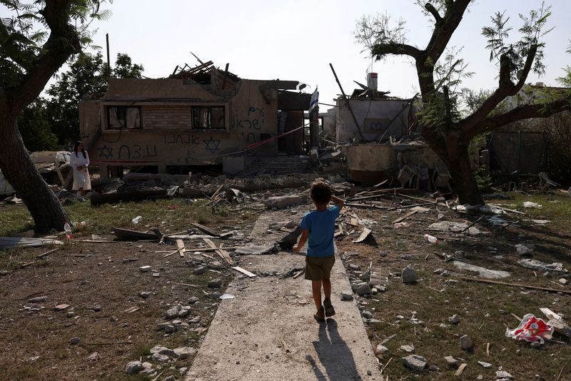 A child looks at a house hit by a rocket fired from the Gaza Strip, in central Israel, amid the ongoing conflict between Israel and the Palestinian Islamist group Hamas, in central Israel, Nov. 3.