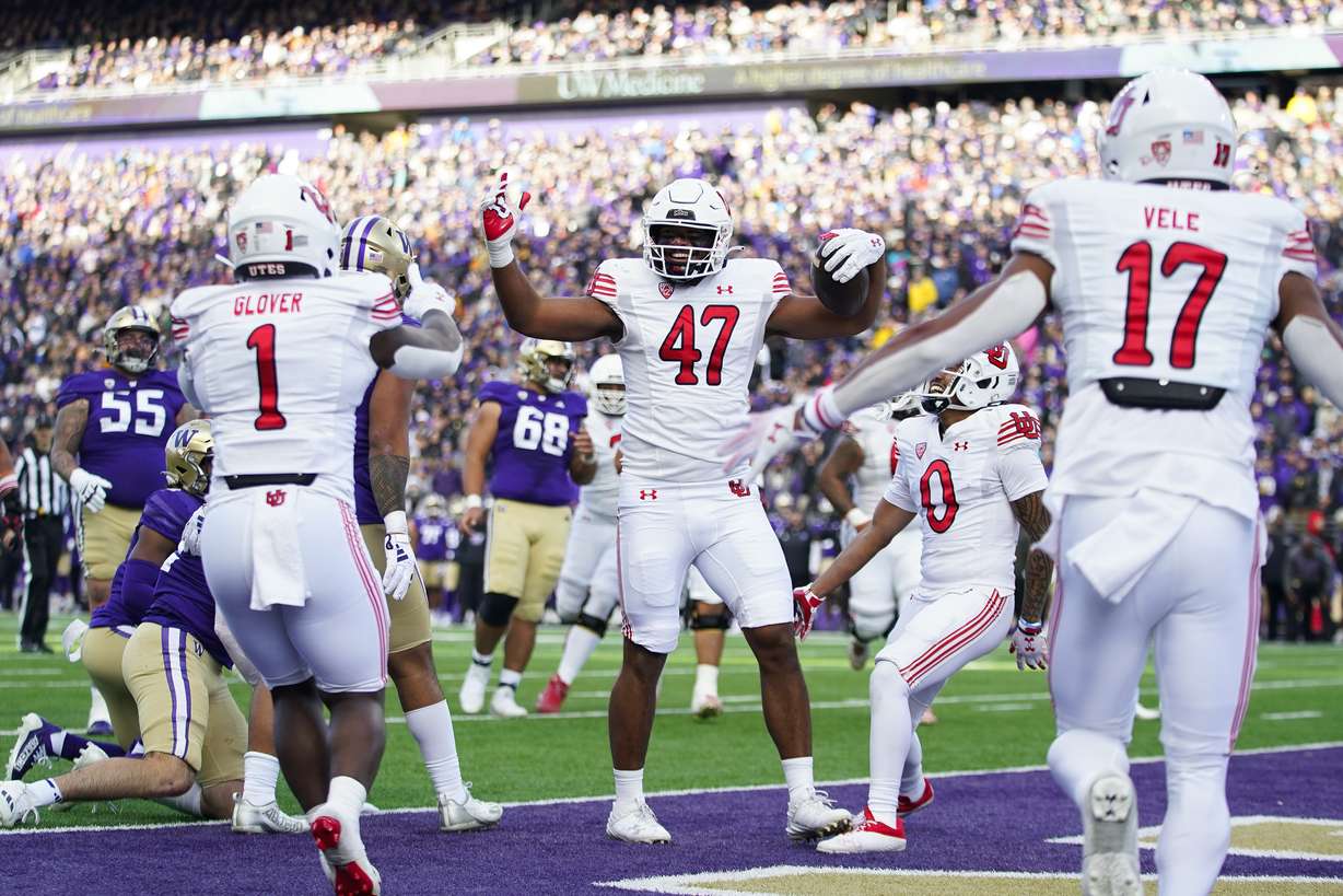 Utah tight end Miki Suguturaga (47) celebrates scoring a touchdown with running back Jaylon Glover (1) and wide receiver Devaughn Vele (17) during the first half of an NCAA college football game against Washington, Saturday, Nov. 11, 2023, in Seattle.
