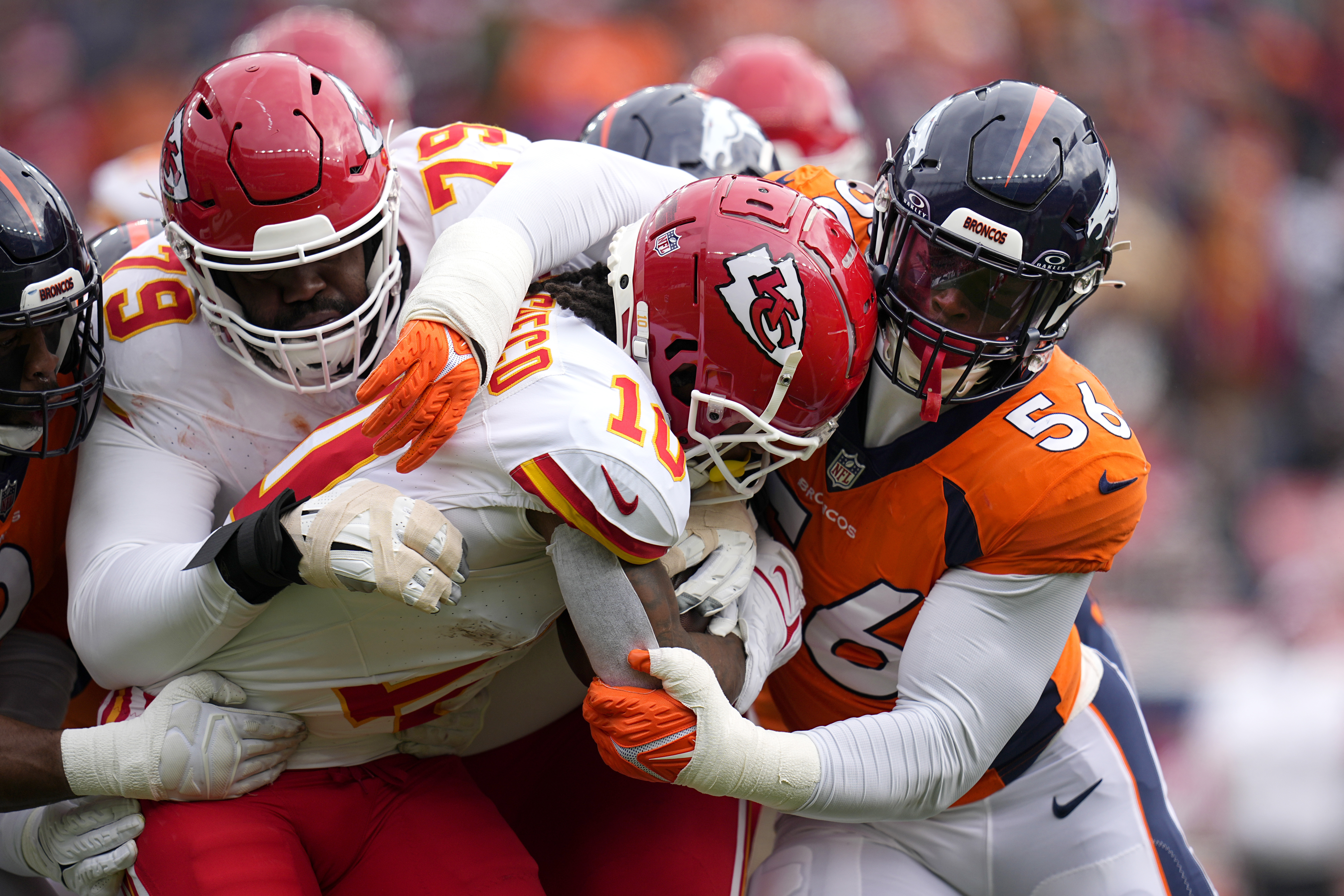 Kansas City Chiefs running back Isiah Pacheco (10) is stopped by Denver Broncos linebacker Baron Browning (56) as Chiefs tackle Donovan Smith (79) defends during the first half of an NFL football game Sunday, Oct. 29, 2023, in Denver.