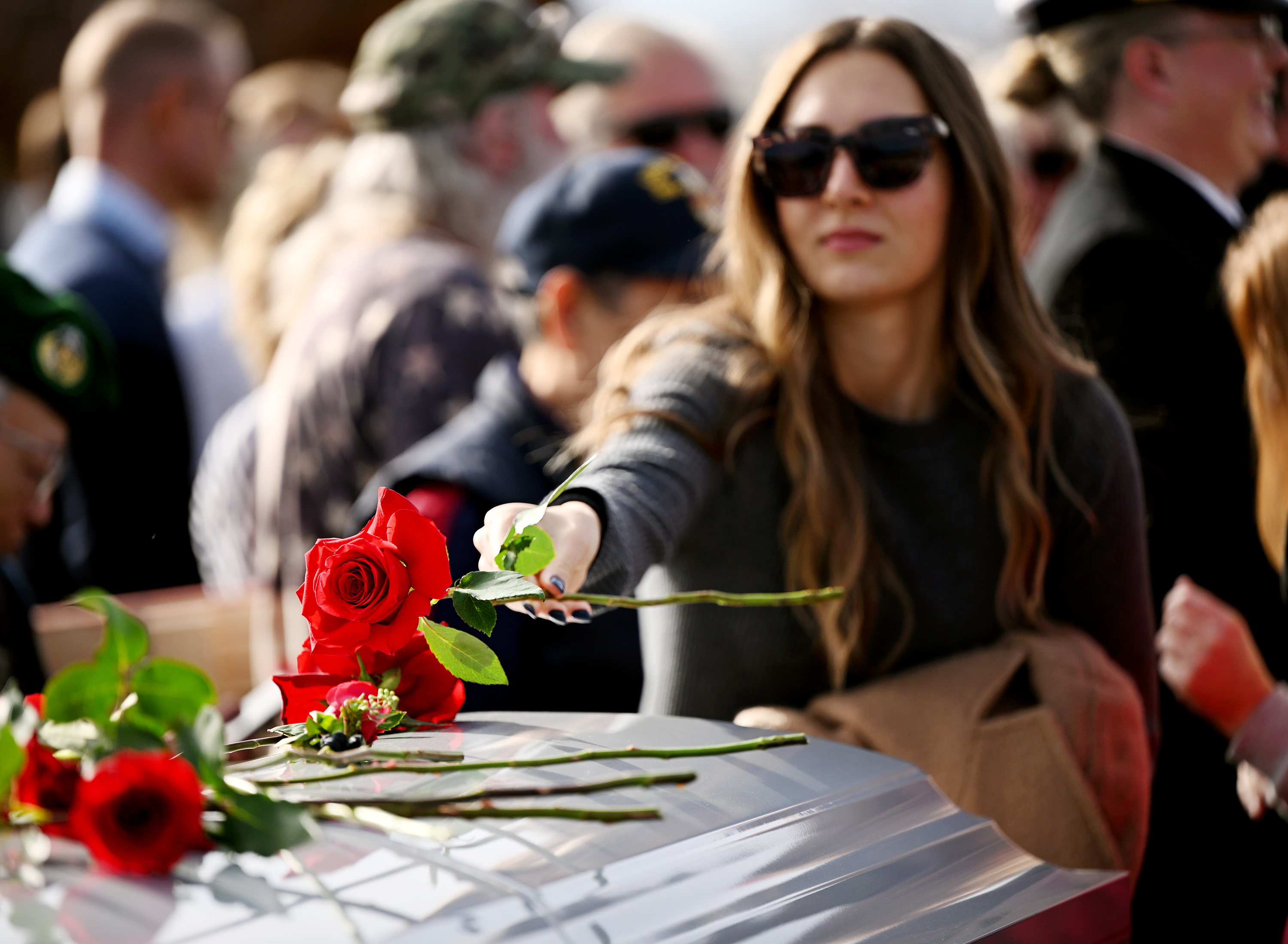 A woman places a rose on the casket as family friends and community members attend a memorial service at American Fork city cemetery for U.S. Marine Corps Capt. Ralph Jim Chipman, who was lost during battle in Vietnam 50 years ago, on Saturday.