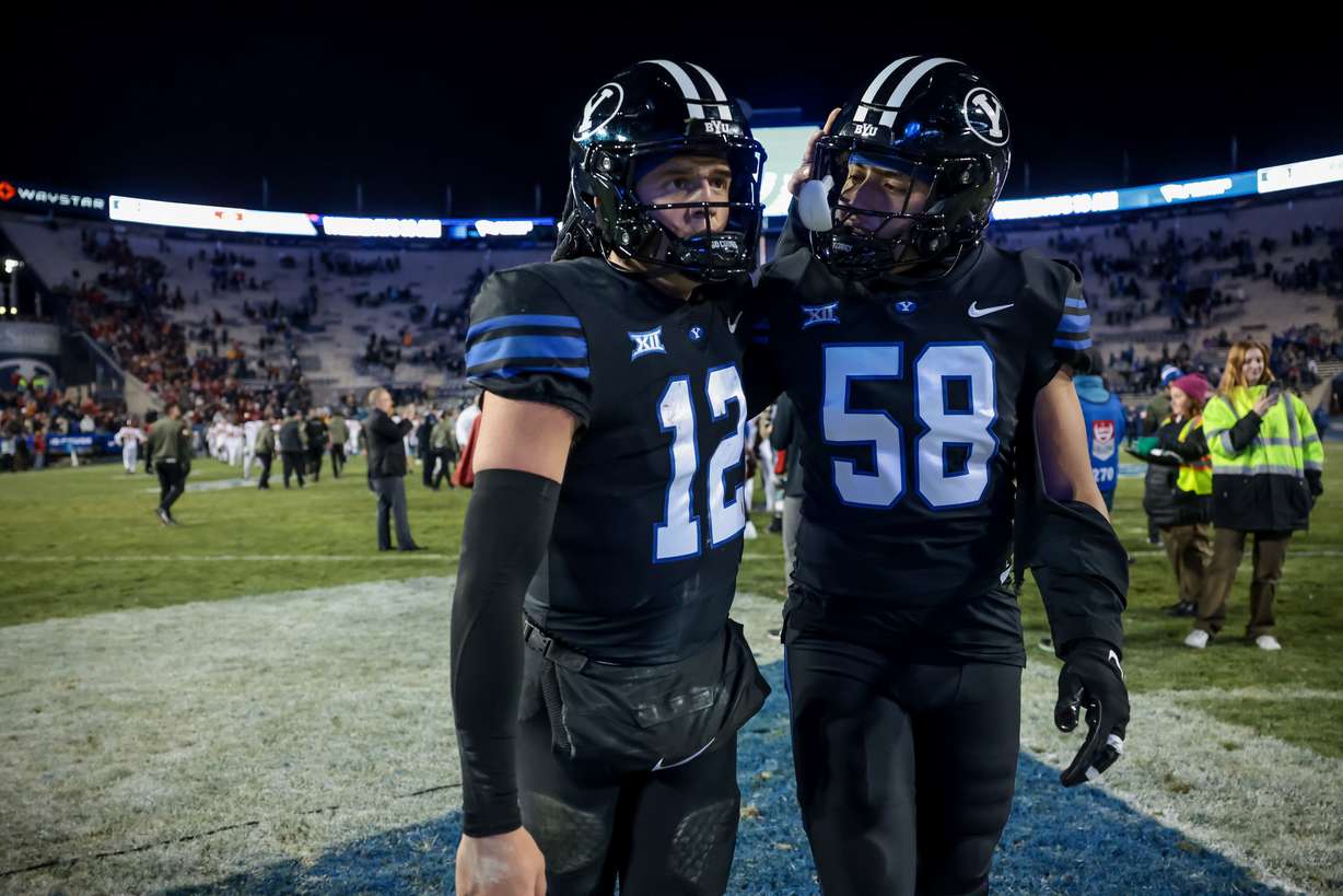 BYU quarterback Jake Retzlaff (12) and defensive end Aisea Moa (58) embrace after the Cougars lost to the Iowa State Cyclones 45-13 at LaVell Edwards Stadium in Provo on Saturday, Nov. 11, 2023.