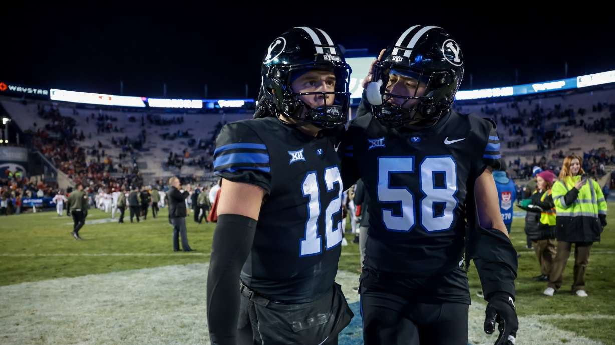 BYU quarterback Jake Retzlaff (12) and defensive end Aisea Moa (58) embrace after the Cougars lost to the Iowa State Cyclones 45-13 at LaVell Edwards Stadium in Provo on Saturday, Nov. 11, 2023.