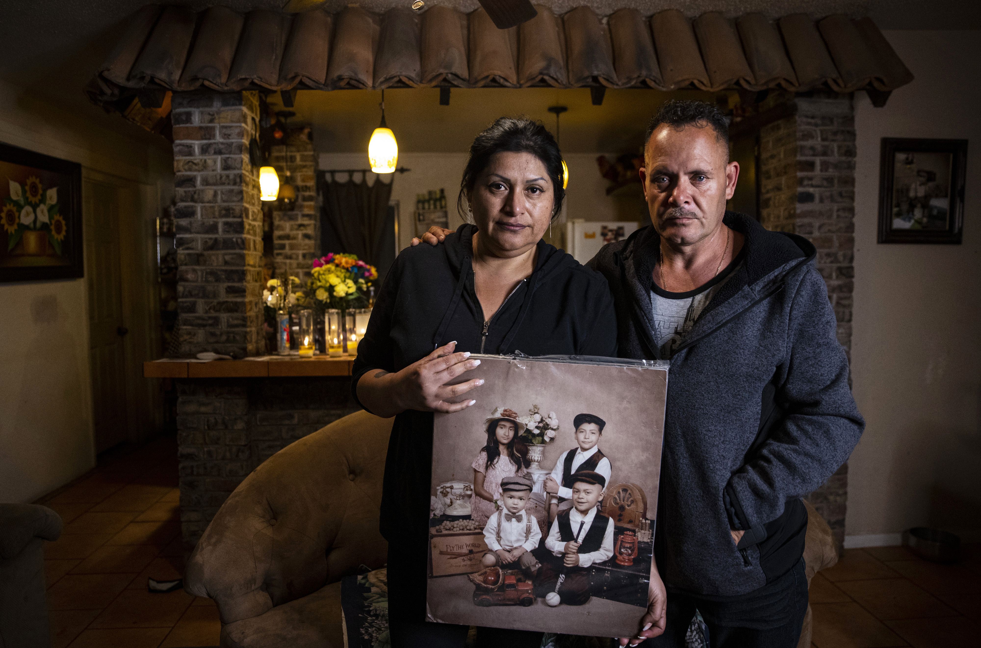Erlinda Zacarias, left, and her husband, Jesus Mejia-Santana, pose for a photo, Jan. 31, 2022, while holding a portrait showing four of their six children who died on Jan. 29, 2022, in a mass-casualty traffic collision in North Las Vegas. 