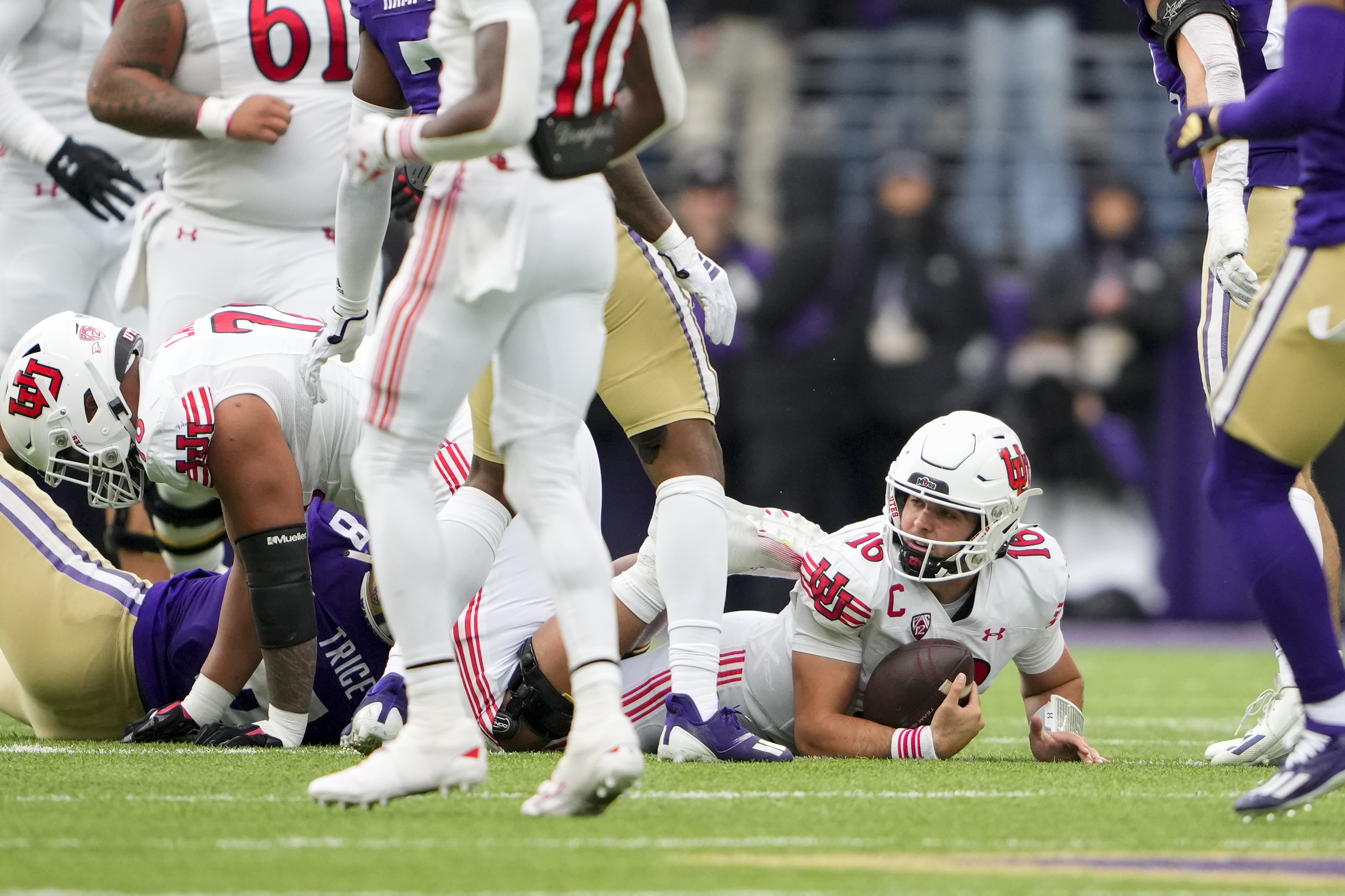 Utah quarterback Bryson Barnes (16) looks up after being tackled by Washington defensive end Bralen Trice (8) during the second half of an NCAA college football game Saturday, Nov. 11, 2023, in Seattle.
