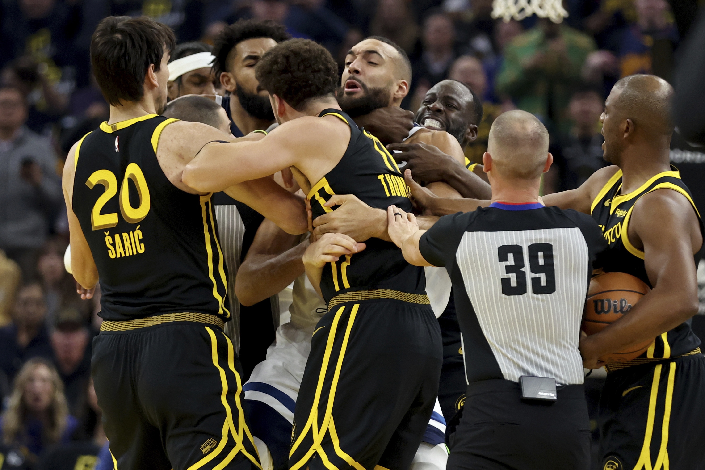 Golden State Warriors' Klay Thompson, front, and Draymond Green, back, get into an altercation with Minnesota Timberwolves center Rudy Gobert, middle, during the first half of an in-season NBA tournament basketball game in San Francisco, Tuesday, Nov. 14, 2023. All three were ejected. 