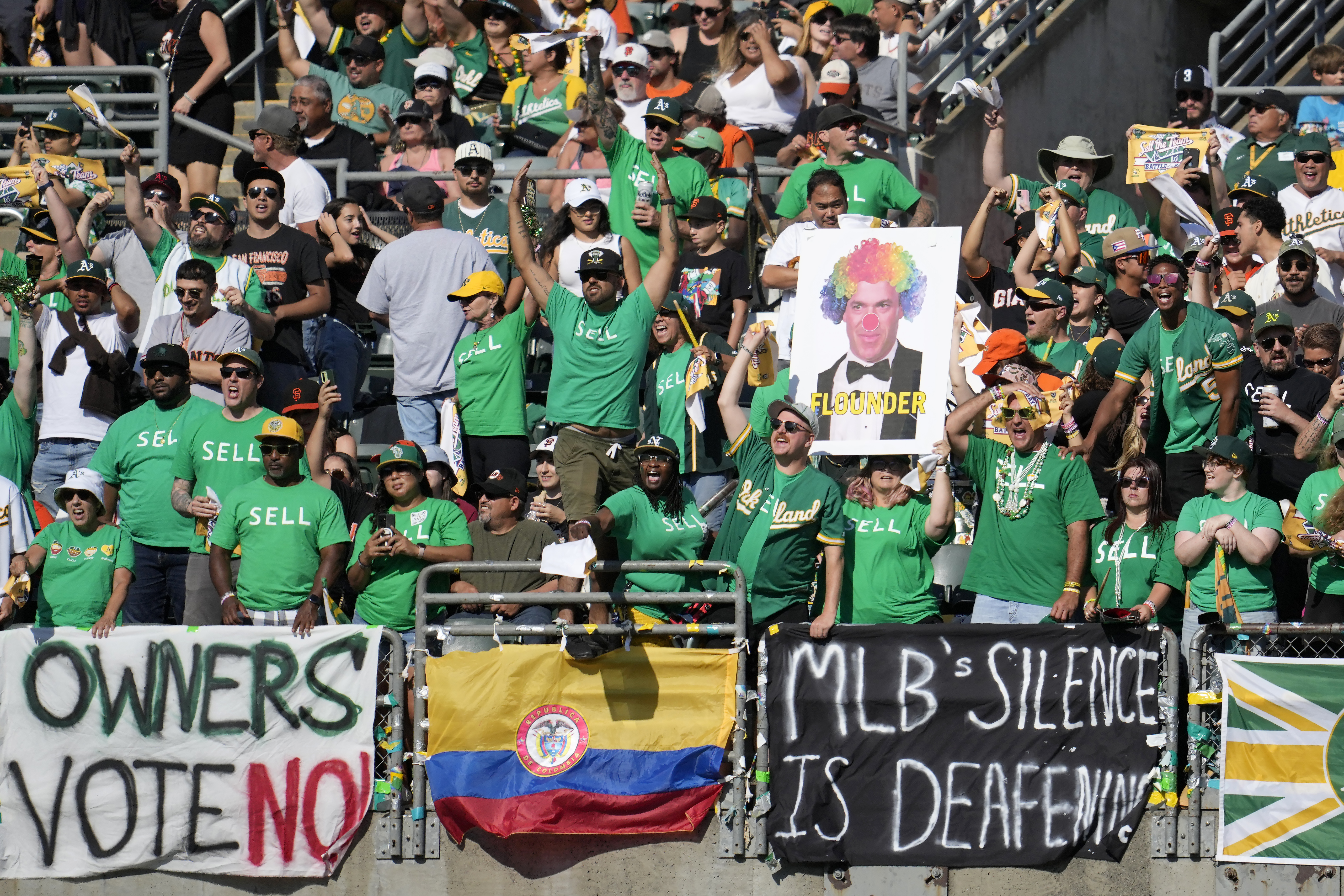 FILE - Oakland Athletics fans in right field yell behind signs protesting the team's potential move to Las Vegas and to call for managment to sell the team during the fifth inning of a baseball game between the Athletics and the San Francisco Giants in Oakland, Calif., Saturday, Aug. 5, 2023. Major League Baseball team owners are set to vote Thursday, Nov. 16, on the proposed relocation of the Oakland Athletics to Las Vegas at the end of their league-wide meeting.