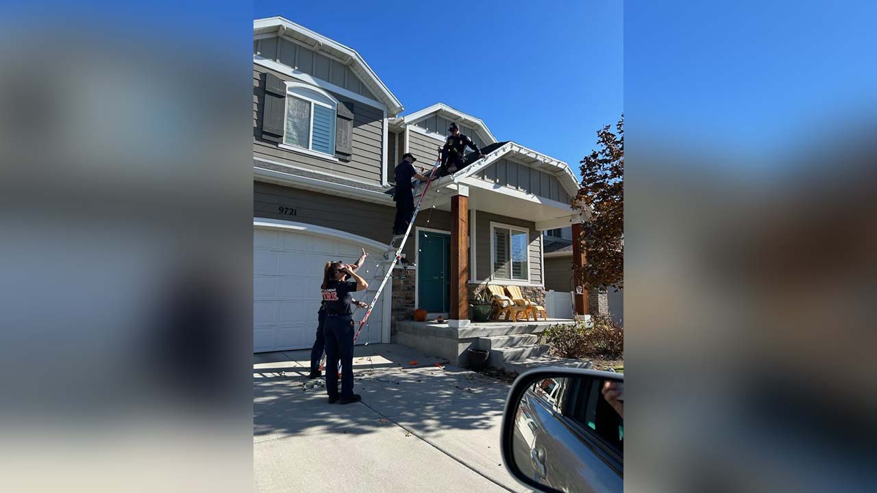 Firemen finish hanging Christmas lights for injured woman