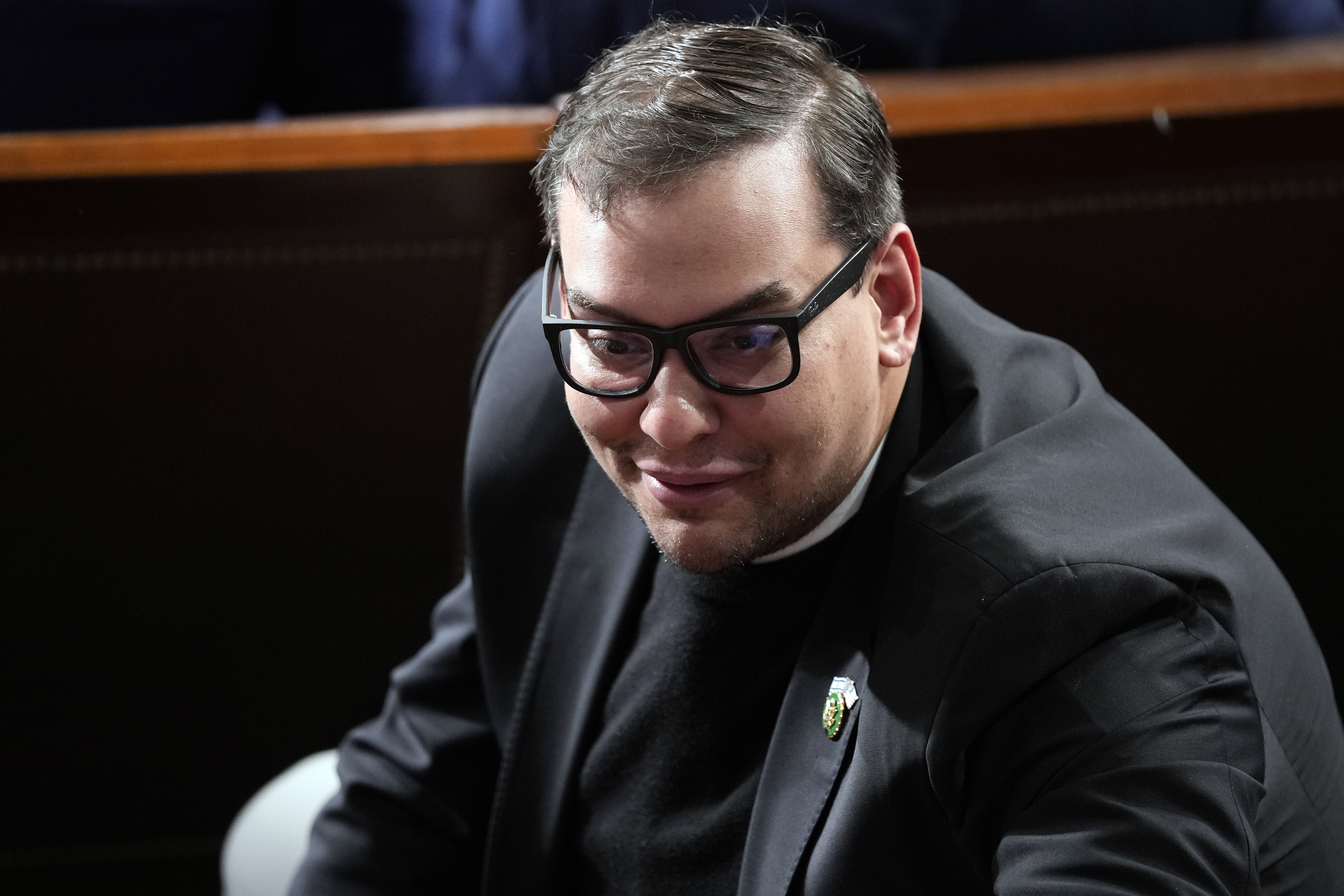 Rep. George Santos, R-N.Y., watches as Republicans try to elect Rep. Mike Johnson, R-La., to be the new House speaker, at the Capitol in Washington, Oct. 25. Santos said Thursday he will not run for reelection in 2024 after a scathing House Ethics Committee report on his conduct cited "overwhelming evidence" of lawbreaking.