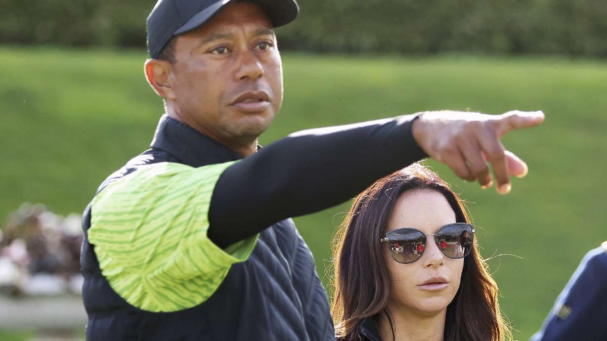 FILE - Tiger Woods, left, and Erica Herman appear on the 18th green during the JP McManus Pro-Am at Adare Manor, Limerick, Ireland, July, 4, 2022. Herman, the ex-girlfriend of golf superstar Woods, has dropped her $30 million lawsuit against the trust that owns his $54 million Florida mansion.