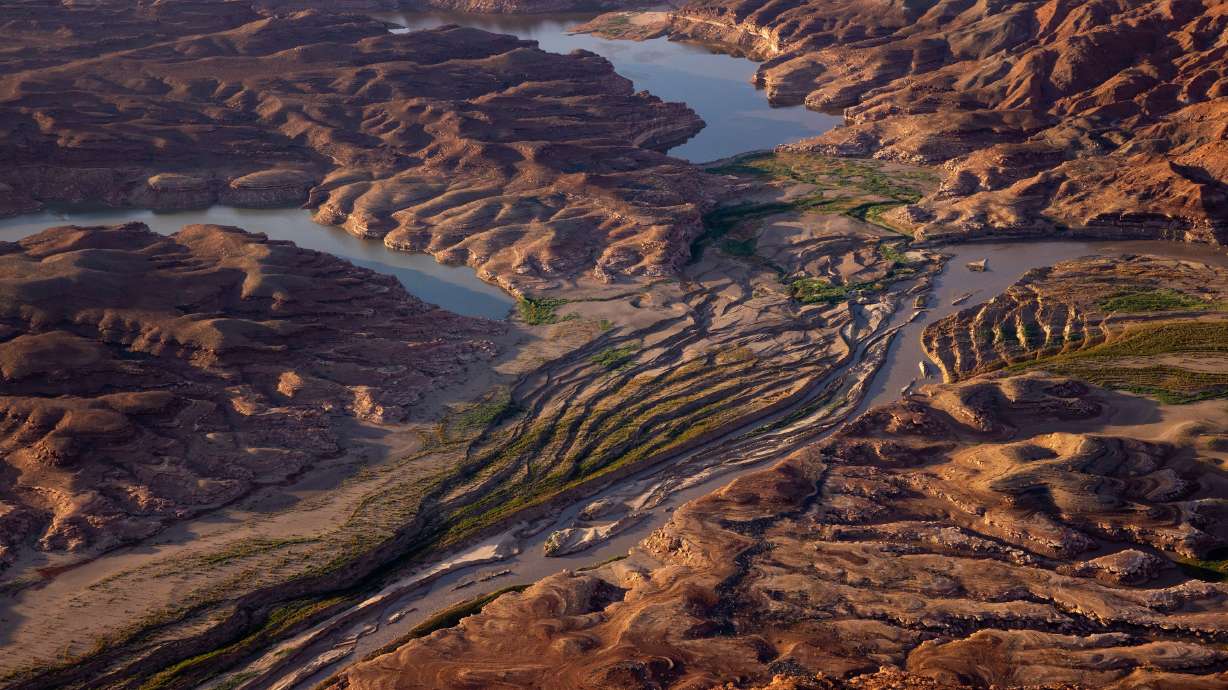 The Colorado River cuts a channel through sediment where Lake Powell has receded in southern Utah on July 22, 2022. At the Utah Water Symposium in Orem Thursday, Amy Hass said in one respect, a compact forged 100 years ago was set up to disappoint.