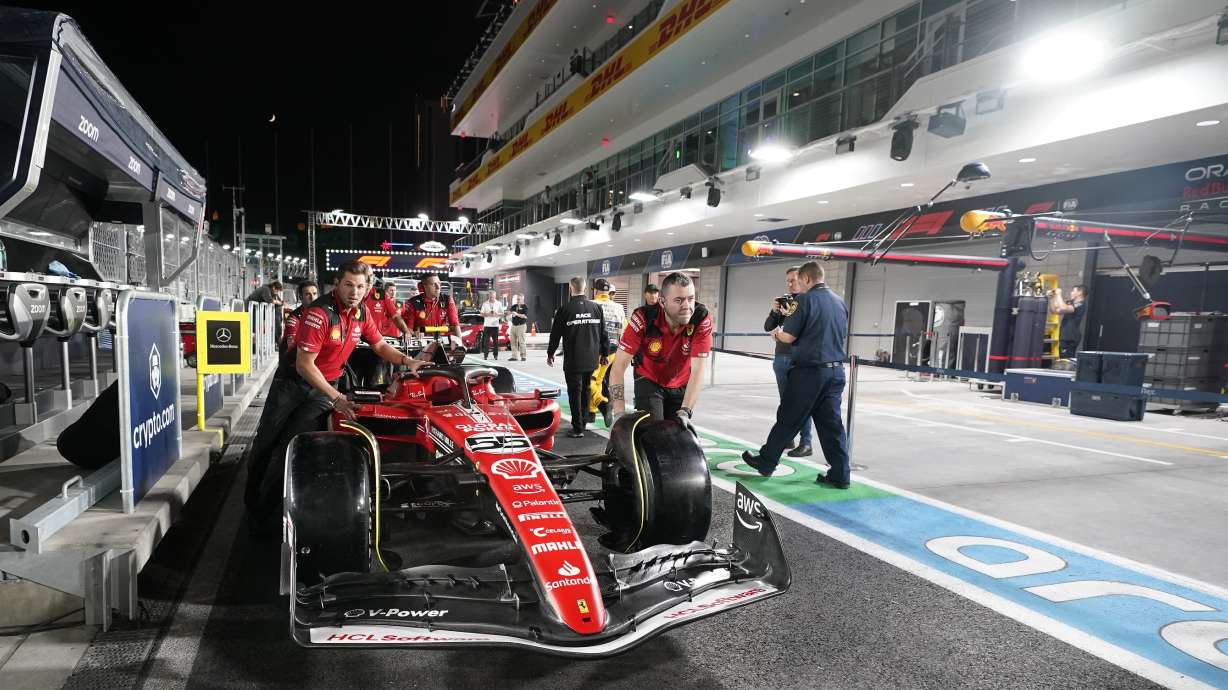 The crew for Ferrari driver Carlos Sainz, of Spain, pushes the car down pit lane before the first practice session for the Formula One Las Vegas Grand Prix auto race, Thursday, Nov. 16, 2023, in Las Vegas.