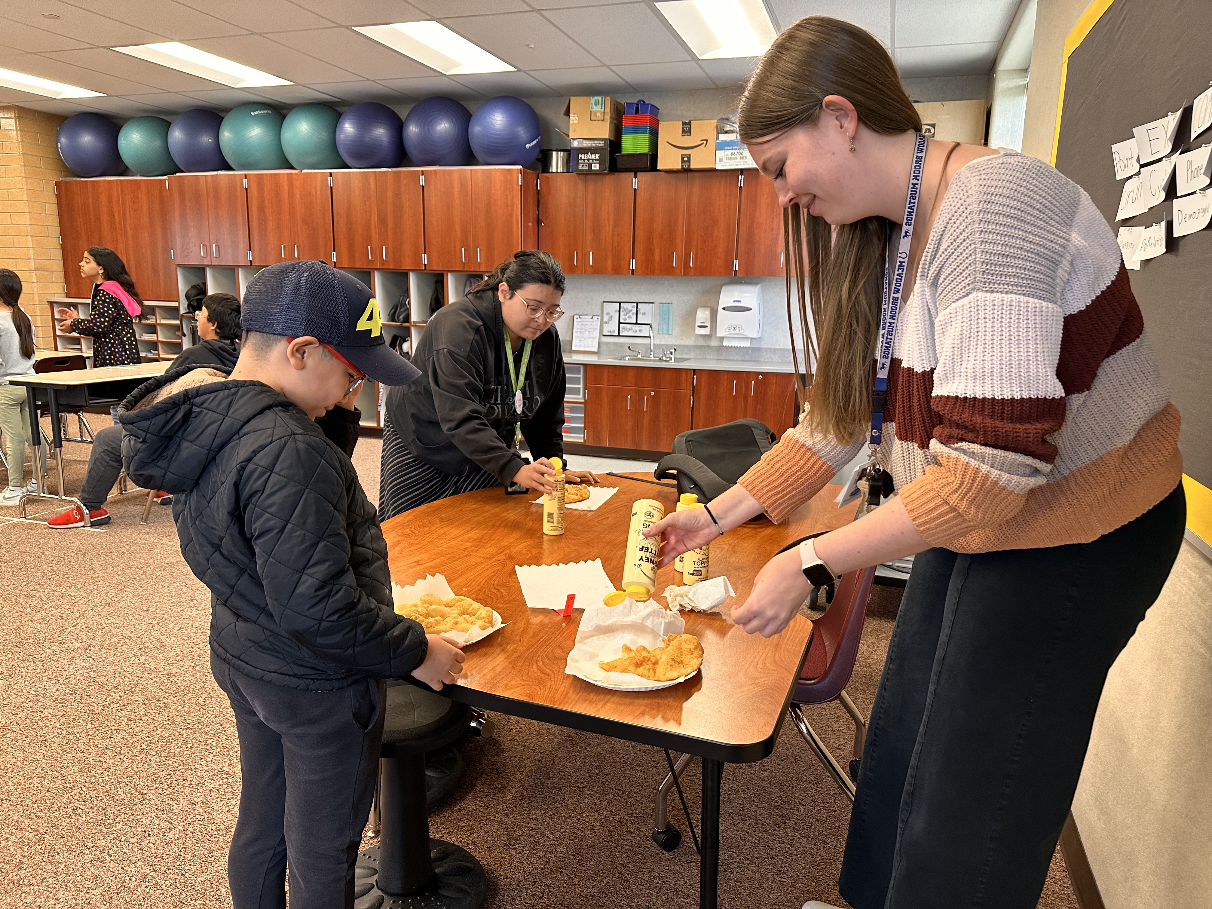 Fifth-grade teacher Alice Owen and 11-year-old Mateas Mendes enjoy some fry bread in Owen's classroom at Meadow Brook Elementary School class on Nov. 13 as part of a lesson from the BYU Arts Partnership's Native American Curriculum Initiative.