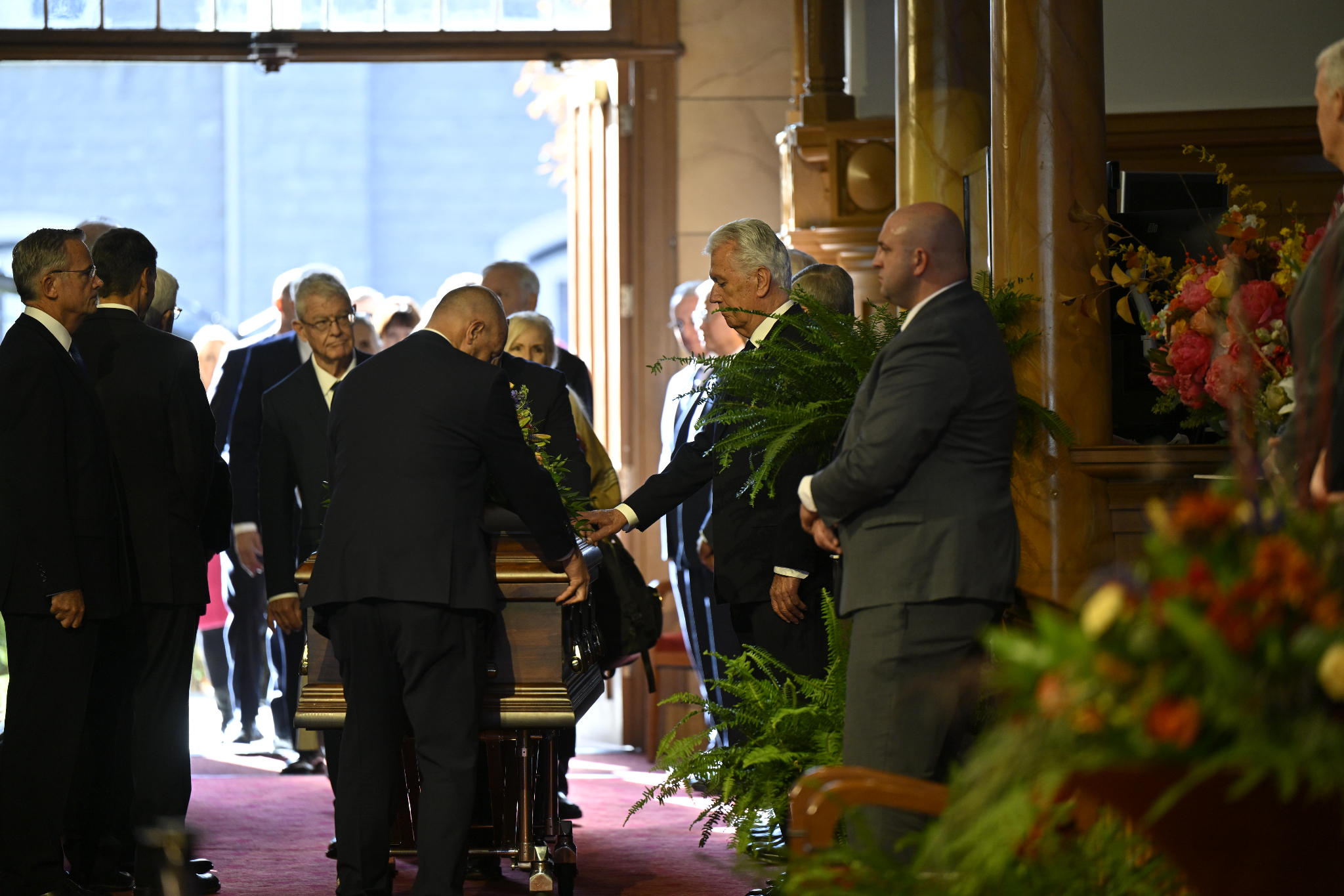Elder Dieter F. Uchtdorf of the Quorum of the Twelve Apostles touches the casket of President M. Russell Ballard casket before the funeral services are held on Friday.