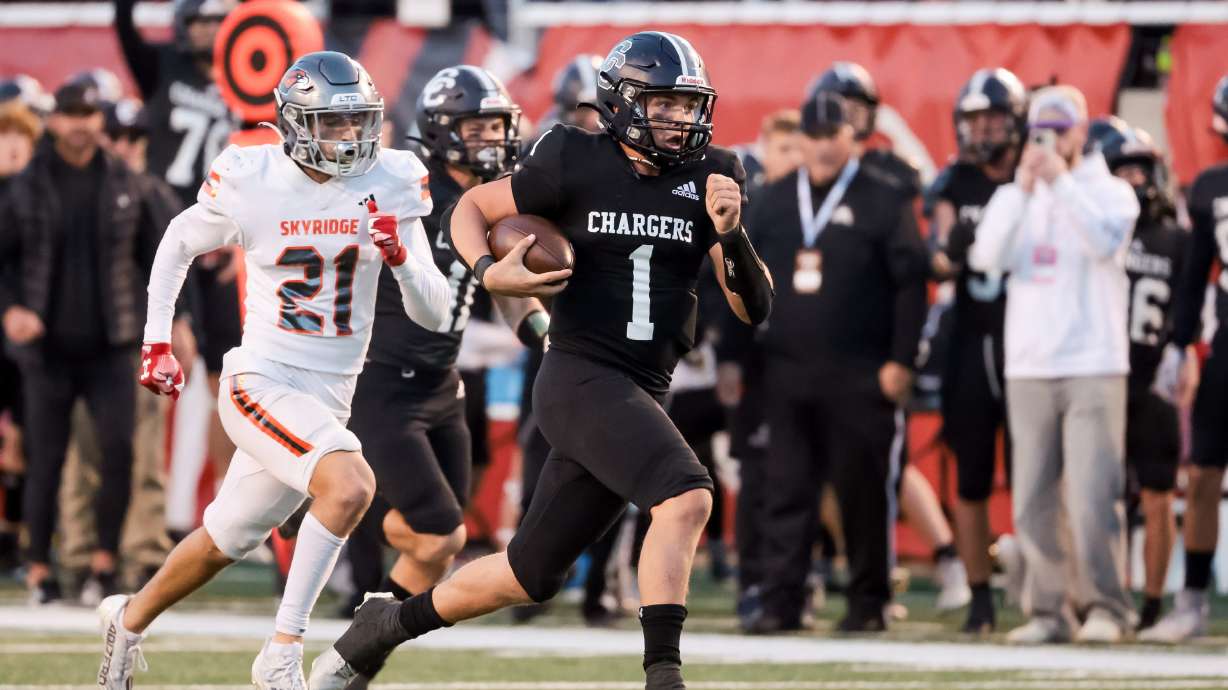 Corner Canyon’s Isaac Wilson runs away from Skyridge defense to score a touchdown in the 6A high school football championship at Rice-Eccles Stadium in Salt Lake City on Friday, Nov. 17, 2023.