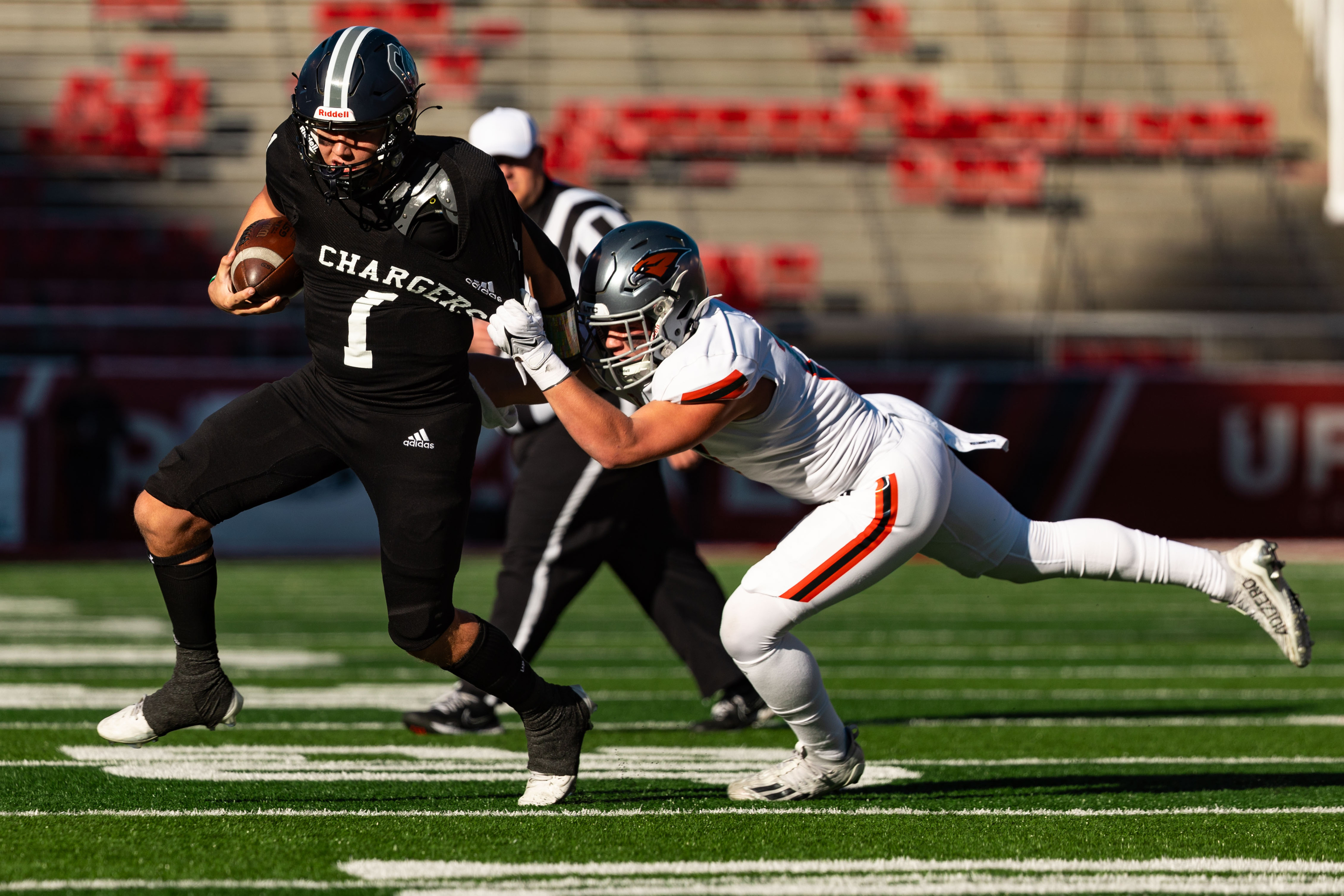 Corner Canyon High School’s Isaac Wilson runs the ball with Skyridge High School’s Noah Bird on defense during the 6A football state championship at Rice-Eccles Stadium in Salt Lake City on Friday, Nov. 17, 2023.