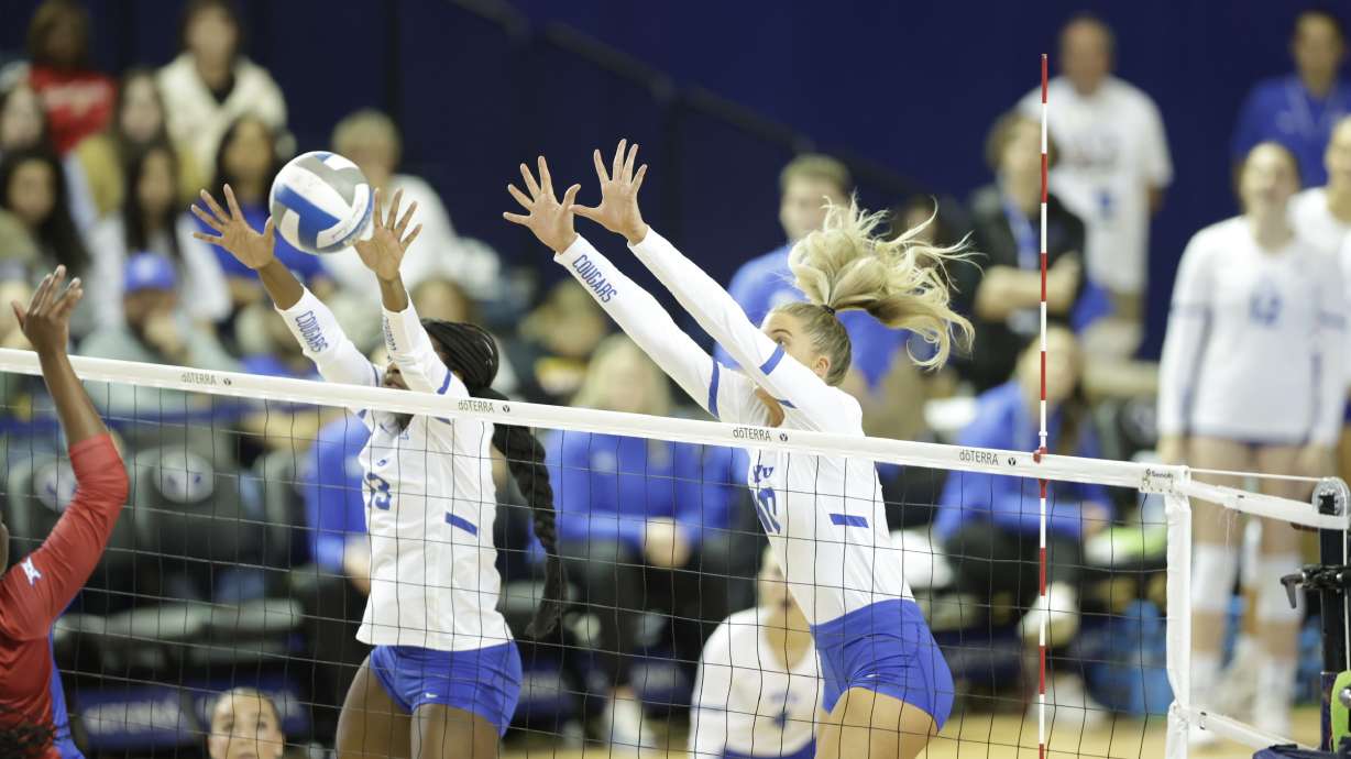 BYU's Mia Lee, left, and Erin Livingston try to block a kill attempt against Kansas, Friday, Nov. 17, 2023, at the Smith Fieldhouse in Provo.
