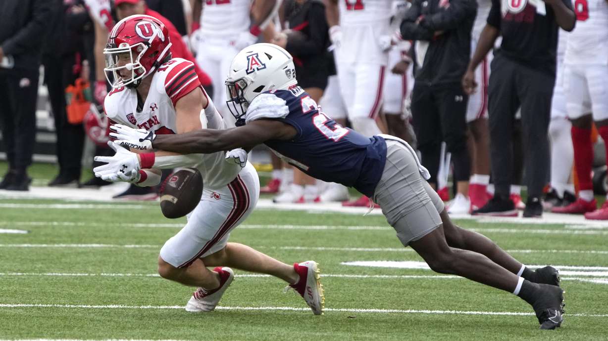 Arizona cornerback Jai-Ayviauynn Celestine knocks the ball away from Utah wide receiver Luca Caldarella (13) during the second half of an NCAA college football game, Saturday, Nov. 18, 2023, in Tucson, Ariz.