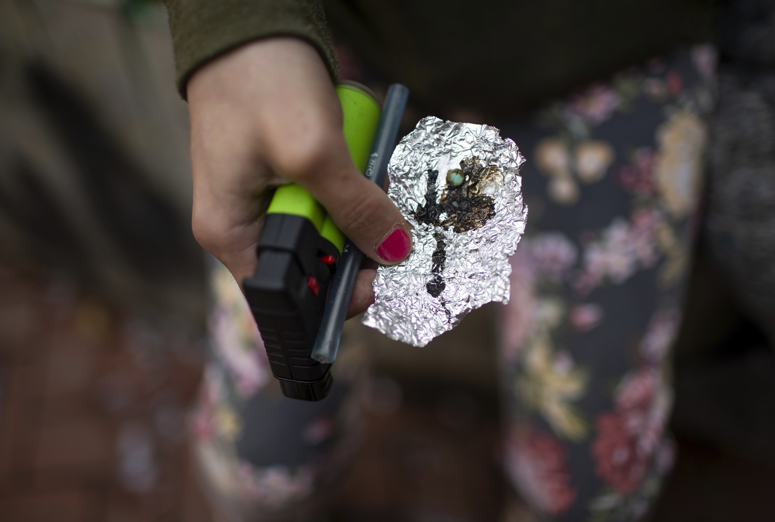A person holds drug paraphernalia near the Washington Center building on SW Washington St. in downtown Portland on April 4. Oregon's pioneering drug decriminalization law is facing a backlash amid a surge in public drug use fueled by fentanyl and an increase in synthetic opioid overdose deaths.