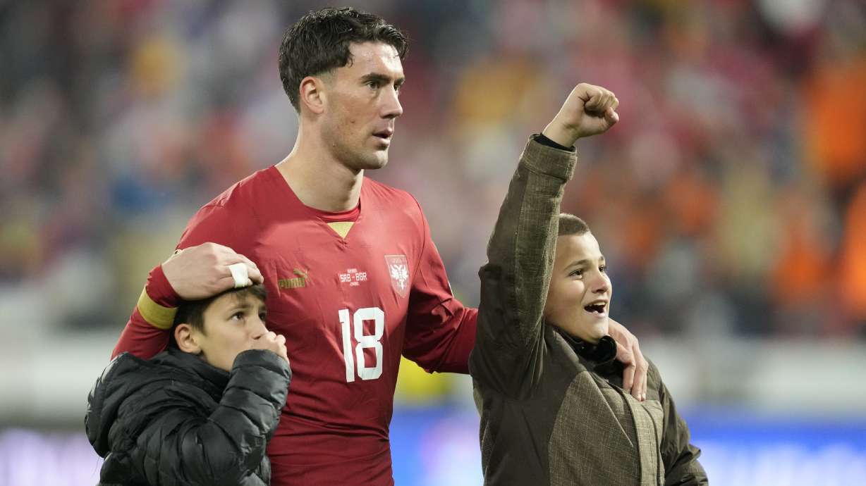 Serbia's Dusan Vlahovic reacts with his sons after the Euro 2024 group G qualifying soccer match between Serbia and Bulgaria at the Dubocica stadium in Leskovac, Serbia, Sunday, Nov. 19, 2023.