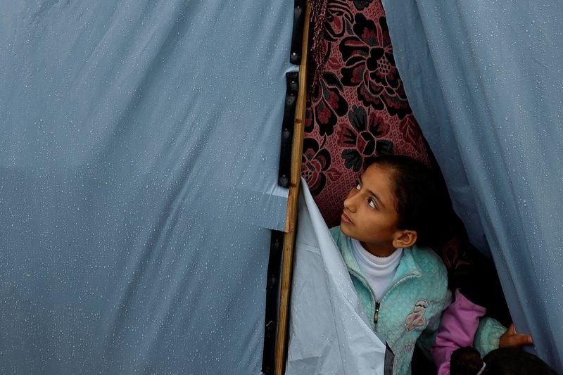 A Palestinian child looks out from a tent following a rainfall, amid the ongoing conflict between Israel and Palestinian Islamist group Hamas, in Khan Younis in the southern Gaza Strip on Sunday.