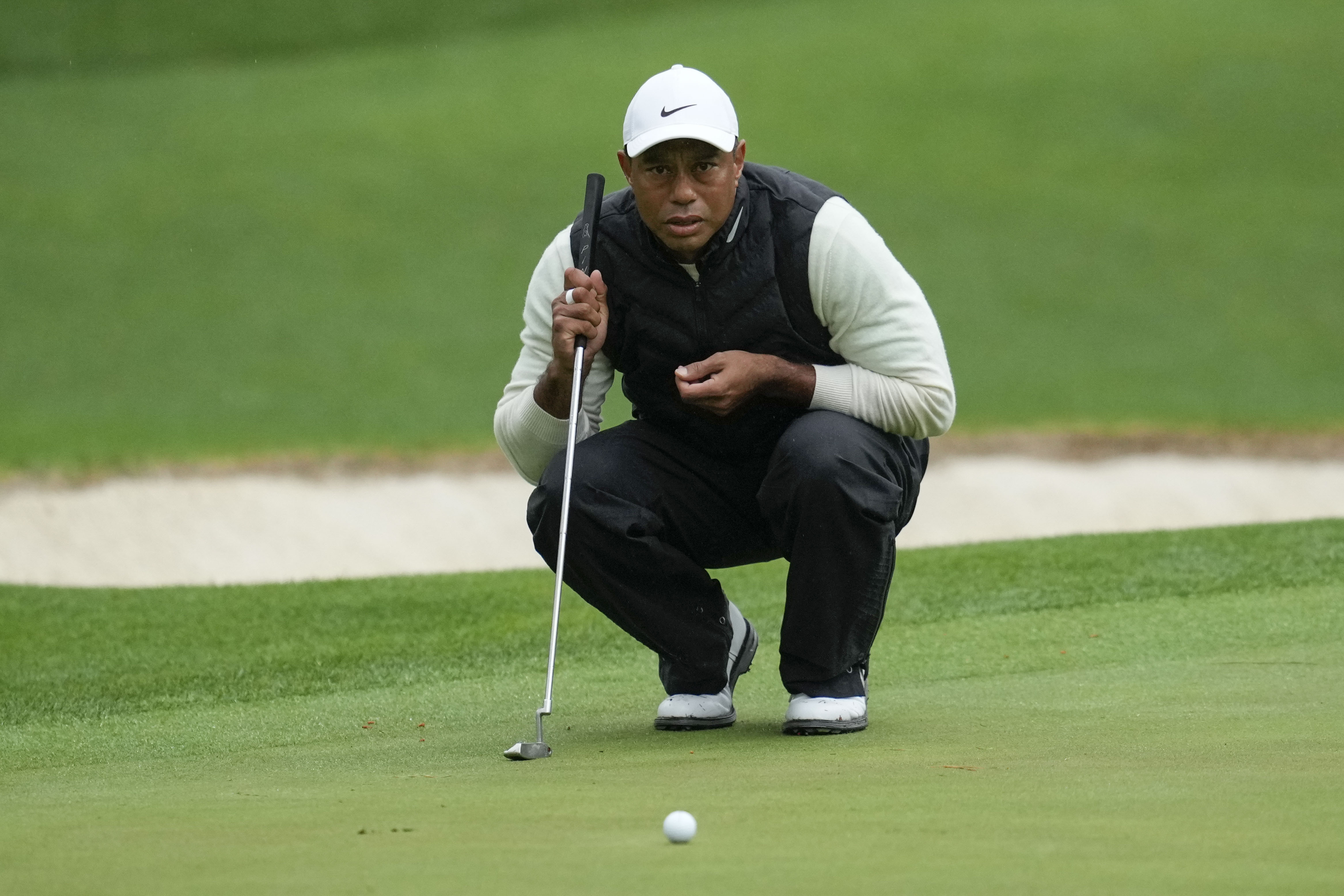 FILE - Tiger Woods lines up a putt on the 16th hole during the weather delayed second round of the Masters golf tournament at Augusta National Golf Club Saturday, April 8, 2023, in Augusta, Ga. Woods says his right ankle that was fused in April is pain-free, but other parts of his leg are not.
