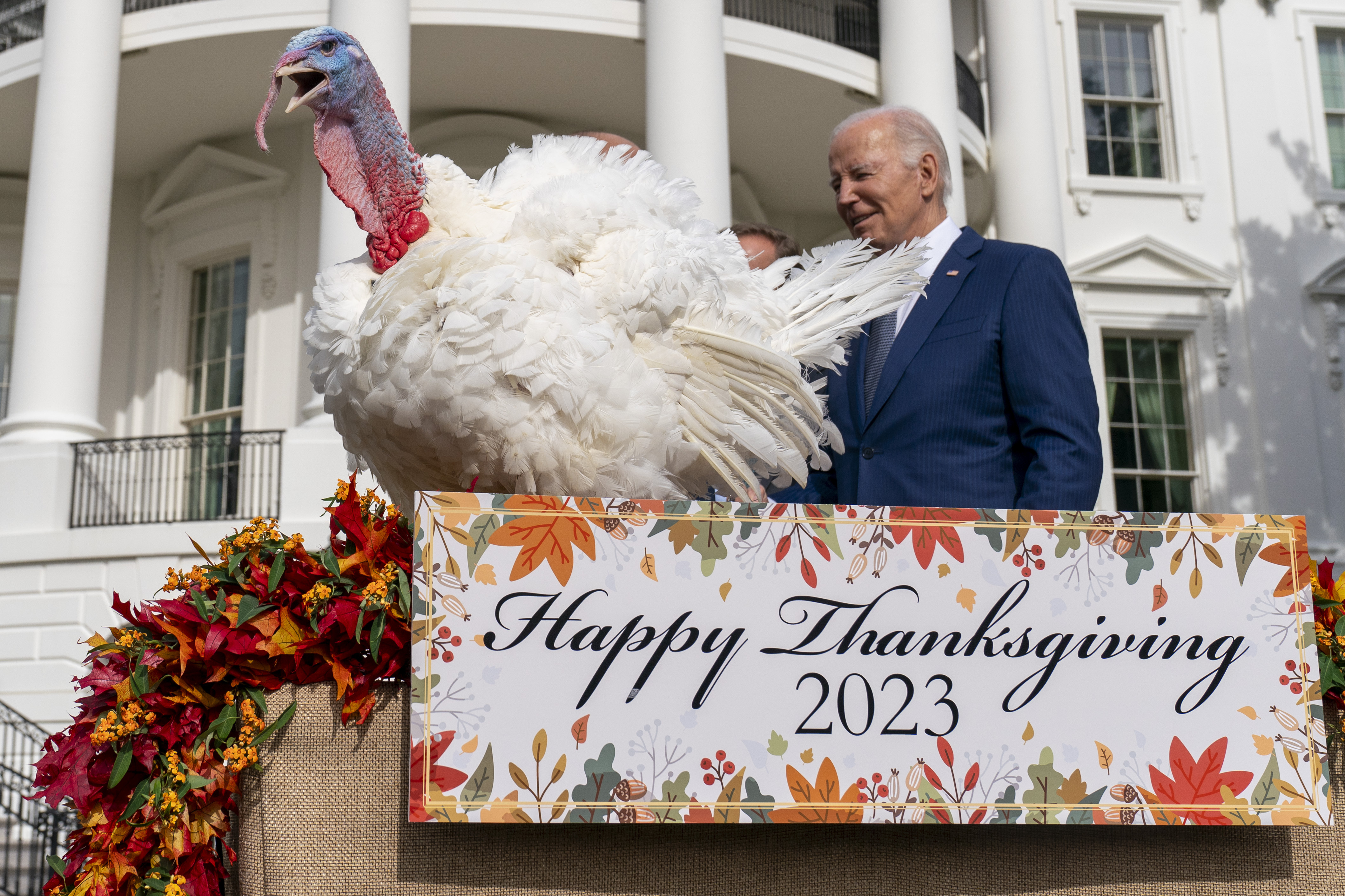 President Joe Biden stands next to Liberty, one of the two national Thanksgiving turkeys, after pardoning them during a ceremony on the South Lawn of the White House in Washington, Monday.