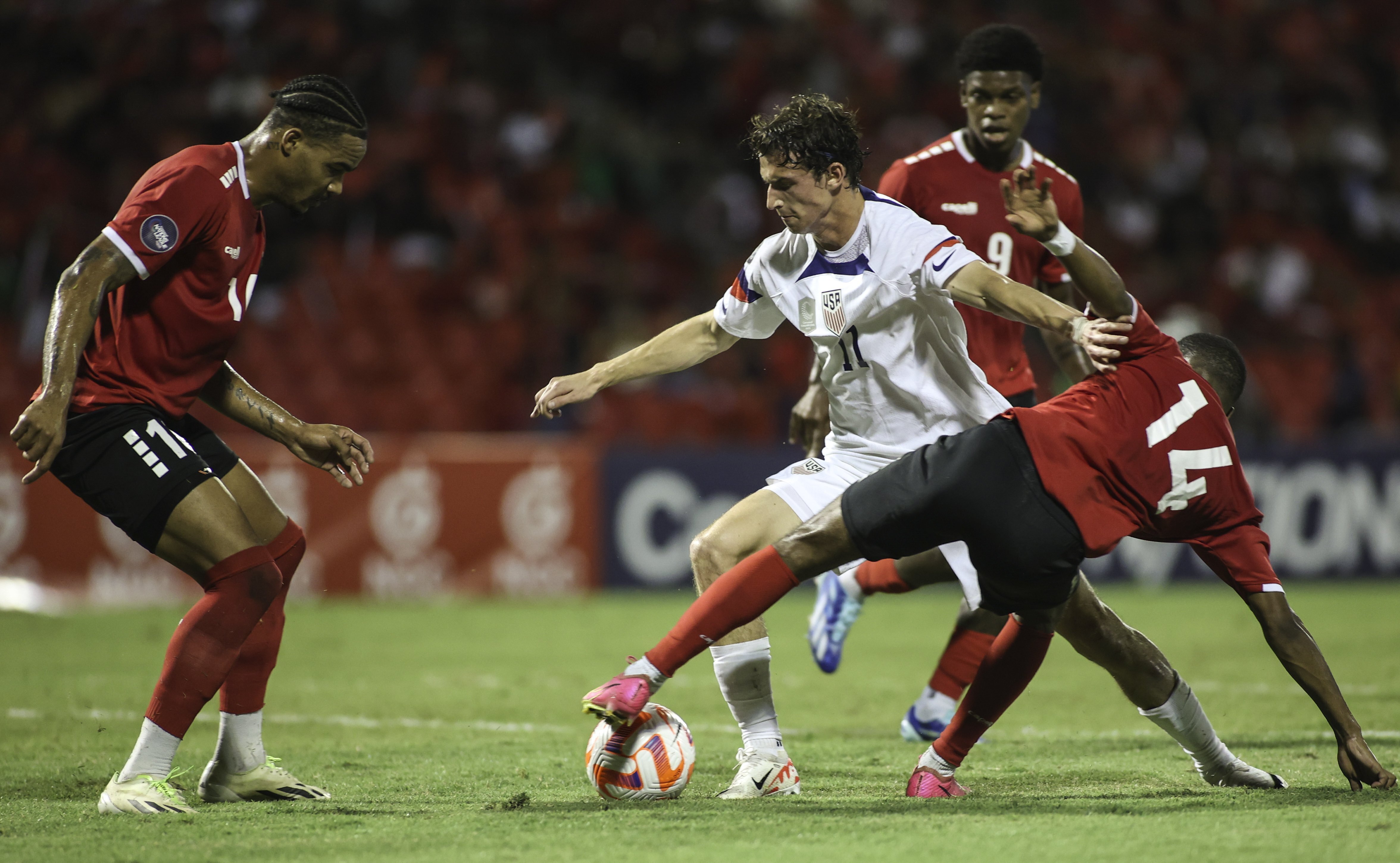 United States' Brenden Aaronson, center, fights for the ball with Trinidad and Tobago's Shannon Gomez, right, and Real Gill, left, during a CONCACAF Nations League quarterfinal soccer match in Port of Spain, Trinidad and Tobago, Monday, Nov. 20, 2023. 