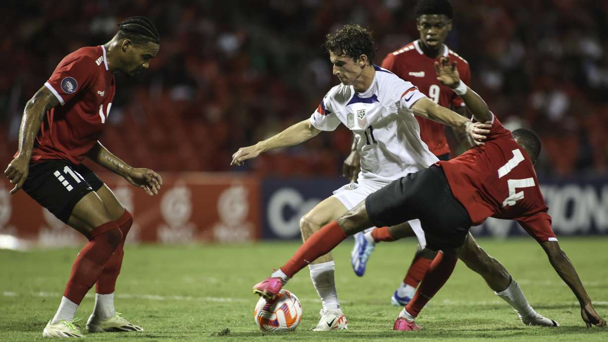 United States' Brenden Aaronson, center, fights for the ball with Trinidad and Tobago's Shannon Gomez, right, and Real Gill, left, during a CONCACAF Nations League quarterfinal soccer match in Port of Spain, Trinidad and Tobago, Monday, Nov. 20, 2023.
