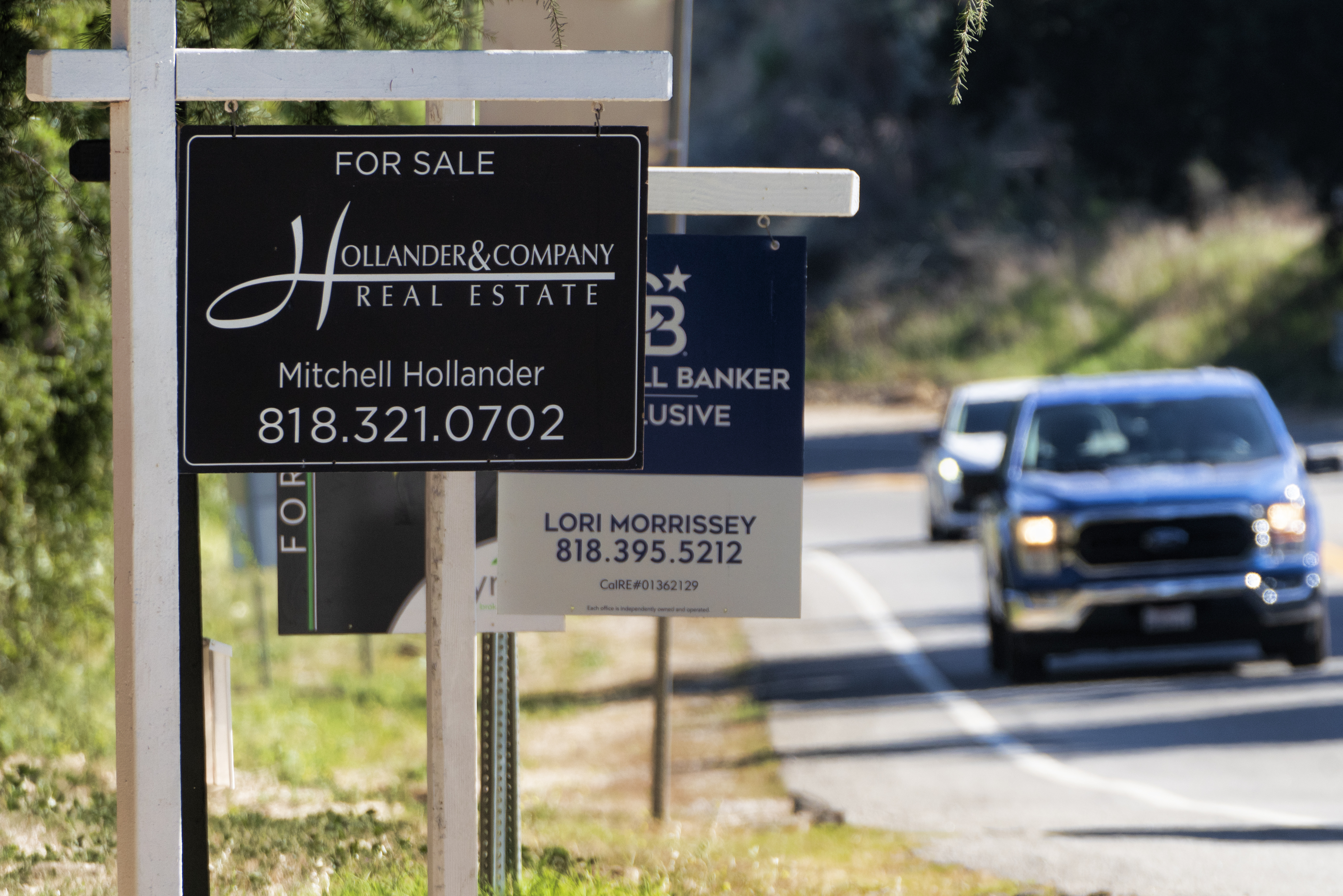 Home sale signs are posted along Topanga Canyon road in Los Angeles on Oct. 19. On Tuesday, the National Association of Realtors said sales of previously occupied homes slumped in October to their slowest pace in more than 13 years.